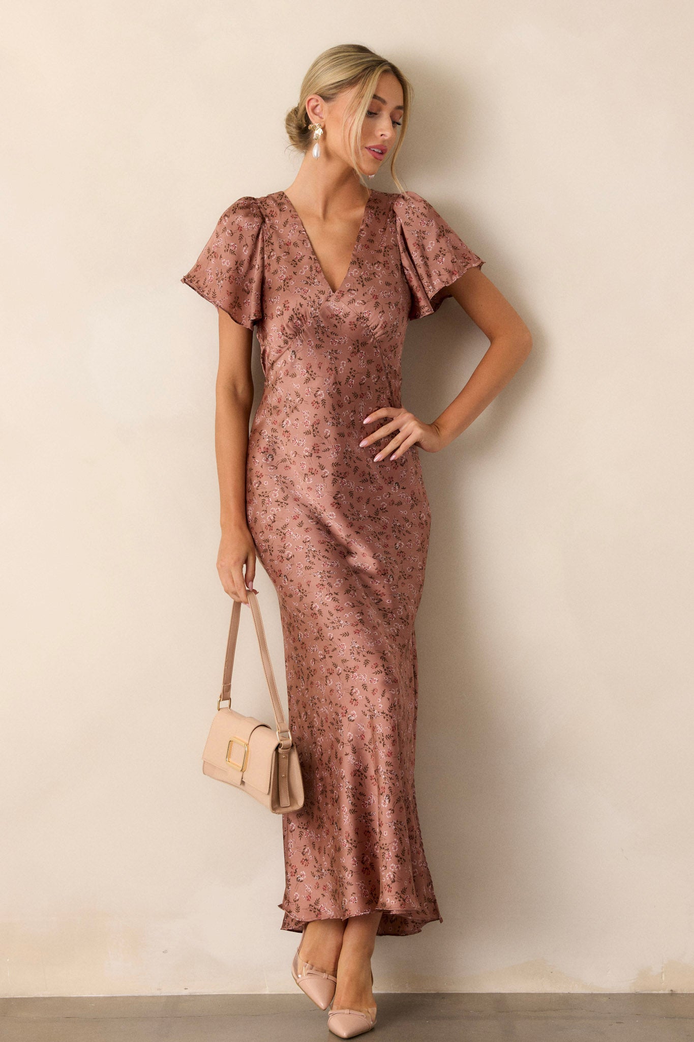 Full-length view of a model wearing the dusty rose dress, emphasizing the plunging v-neckline, flutter sleeves, high leg slit, and the elegant flow of the fabric