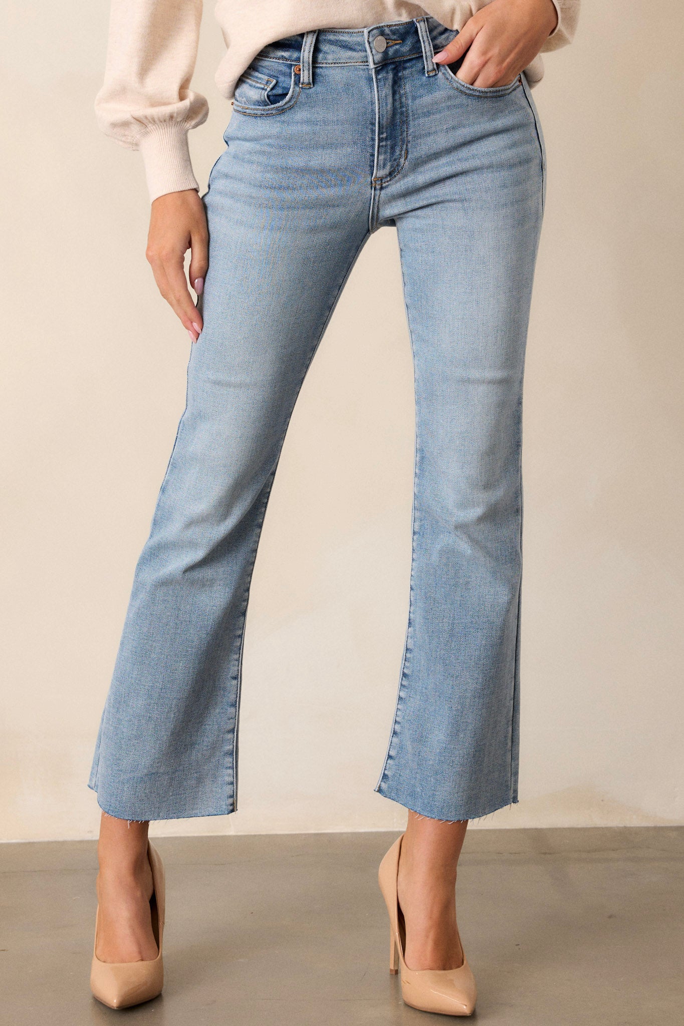 These pants feature a high waisted design, functional hip and back pockets, functional belt loops, a light washed denim, a button zipper closure and a cropped flare leg.