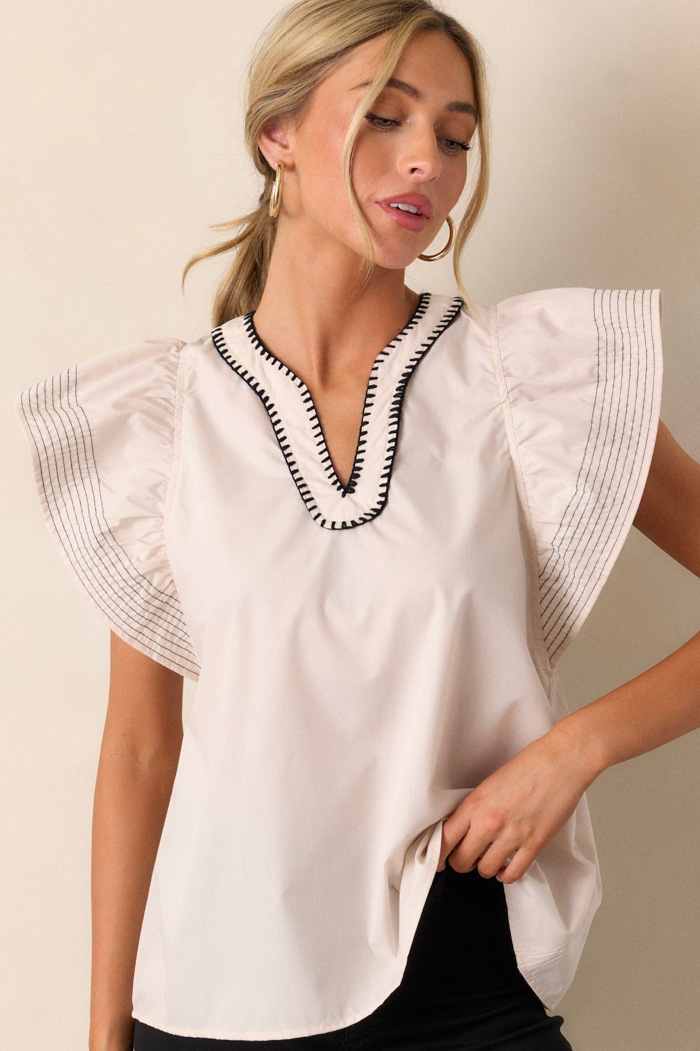 A cropped view of the free cut hem, emphasizing the relaxed style and casual elegance of the blouse.