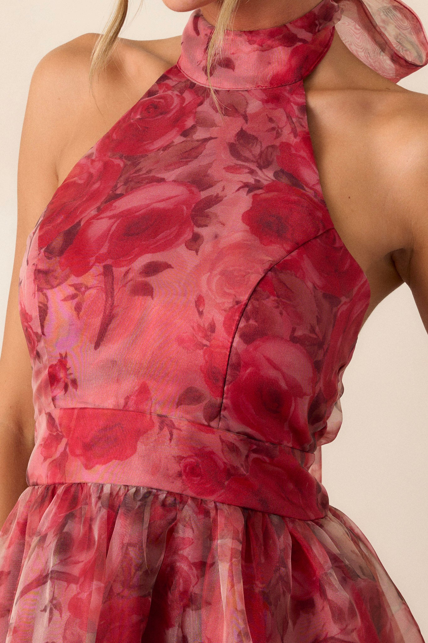 Close-up of the red floral dress focusing on the intricate floral mesh pattern, the halter-neck design, and the slight collar detail at the neckline.