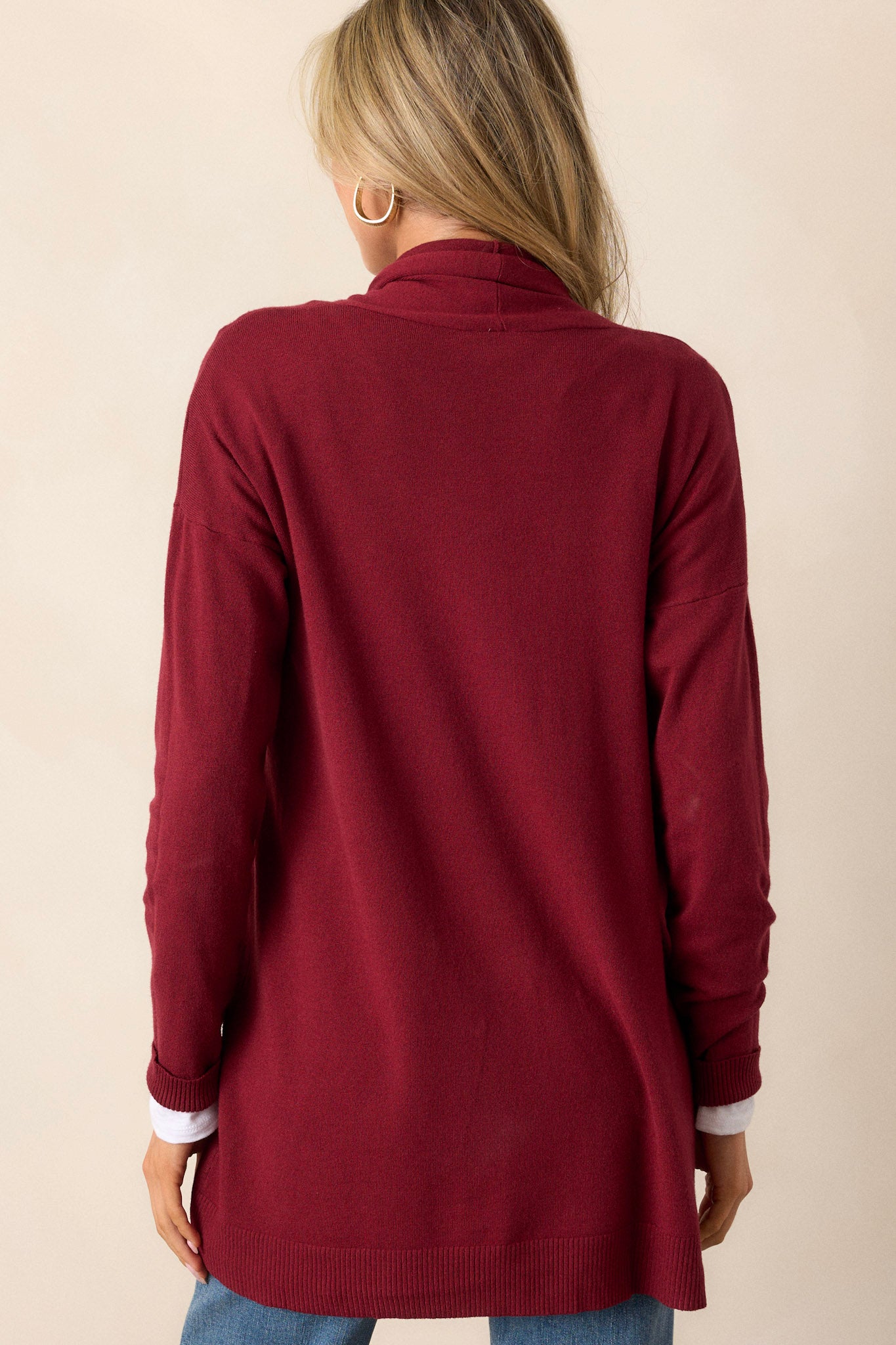 Back view of the cardigan highlighting the large slouchy folded collar and ribbed hemline details.