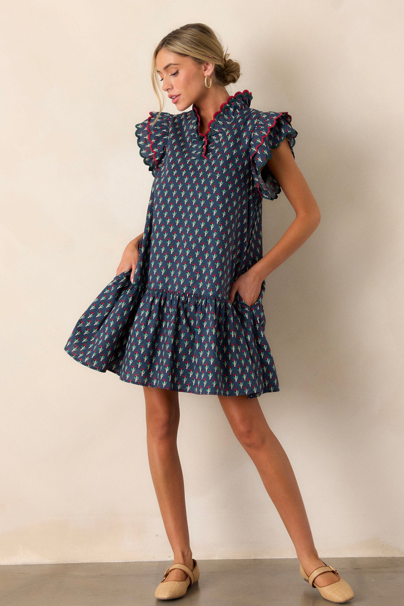 Full-length view of the blue dress featuring two functional pockets, ric-rac detailing, a flowy bottom tier, and flutter cap sleeves