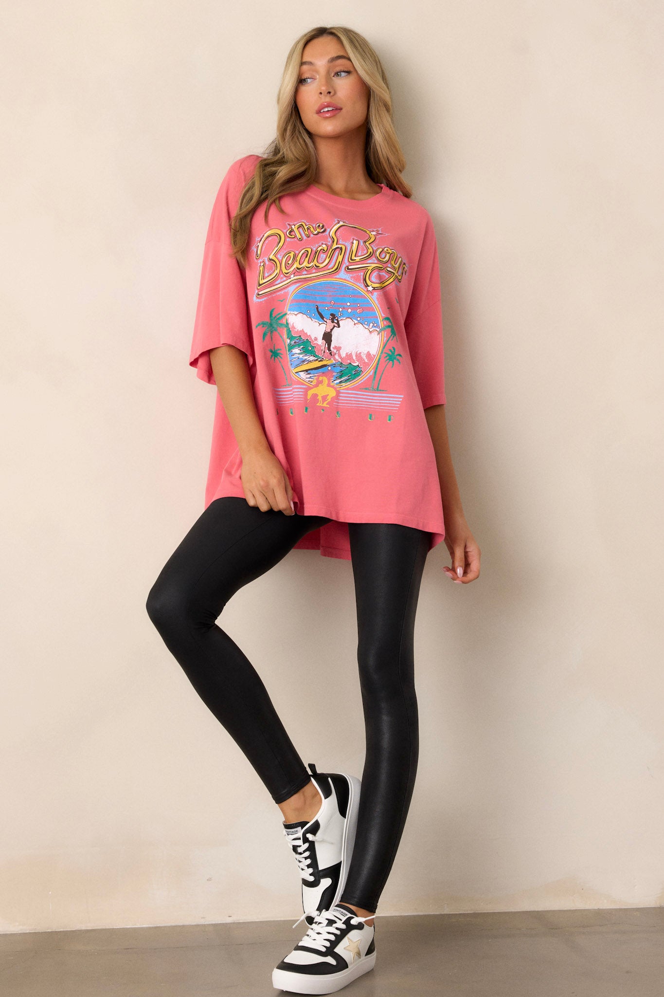 Relaxed-fit pink tee in 100% cotton, featuring a vibrant 'The Beach Boys' graphic on the front, short sleeves, and crew neckline.