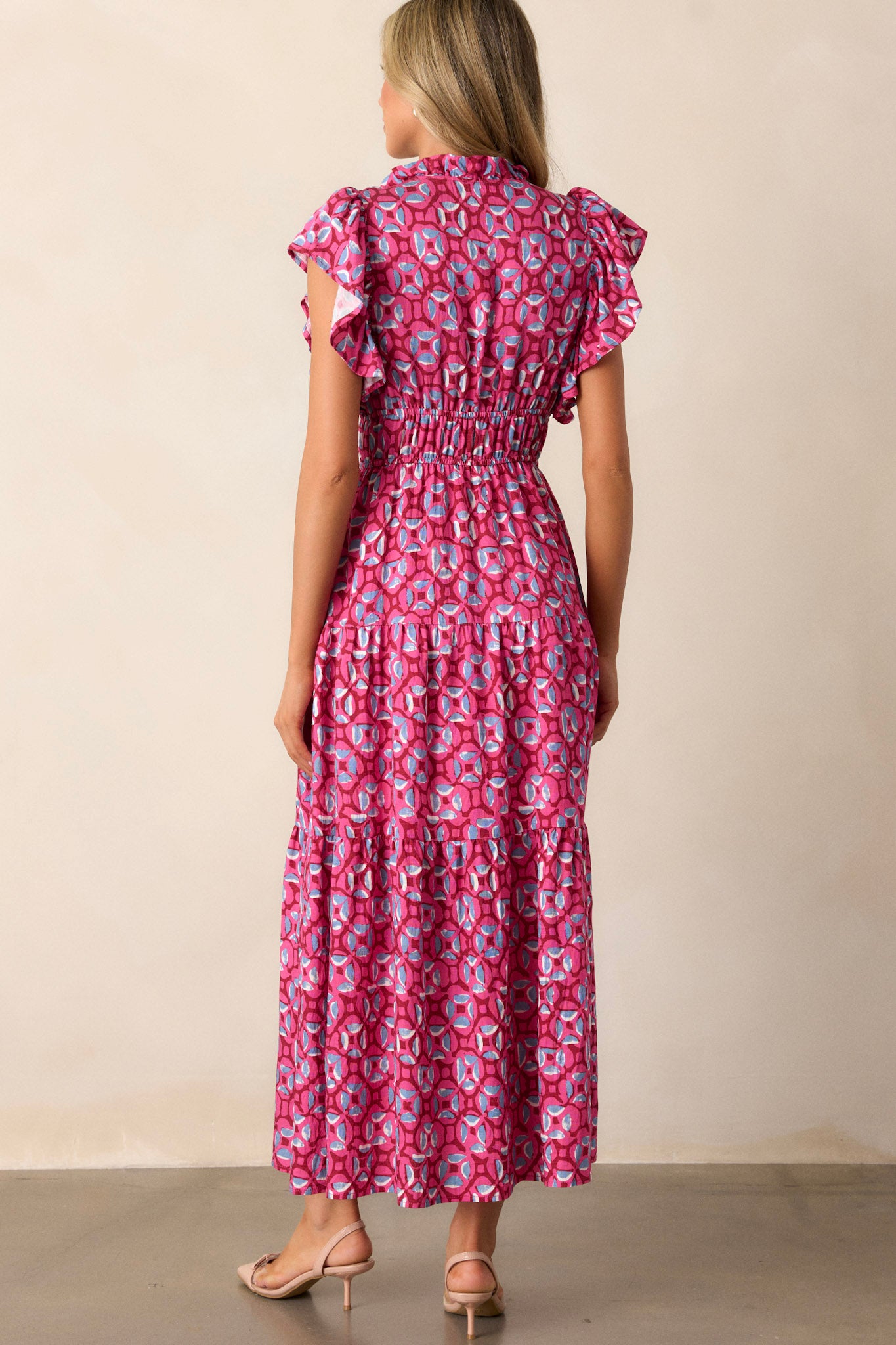 Back view of the pink maxi dress highlighting the continuation of the tiered design, the self-tie drawstring at the neckline, and the overall flow of the dress.