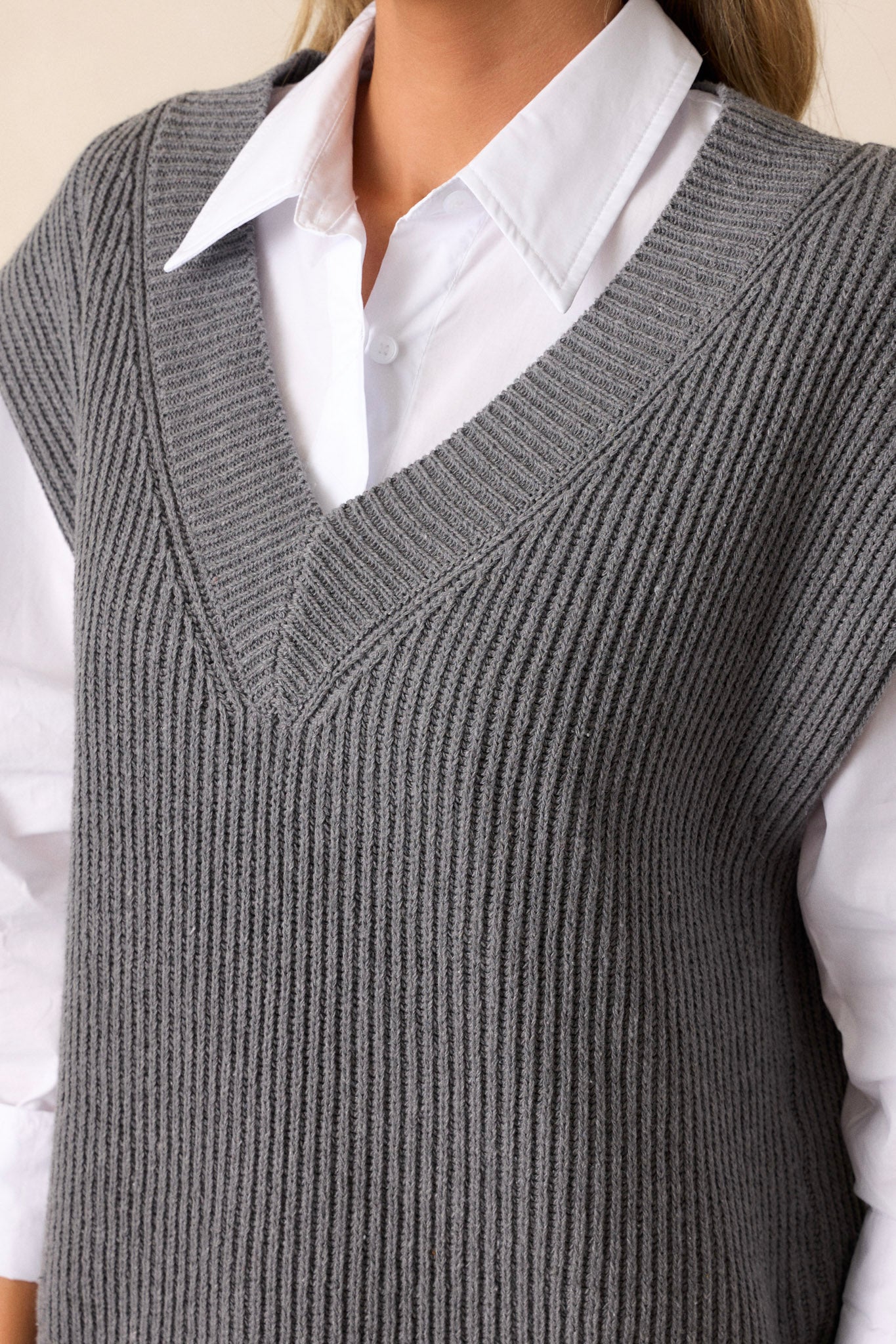 A close-up of the ribbed v-neckline, focusing on the texture and neat stitch pattern that adds structure to the casual vest.