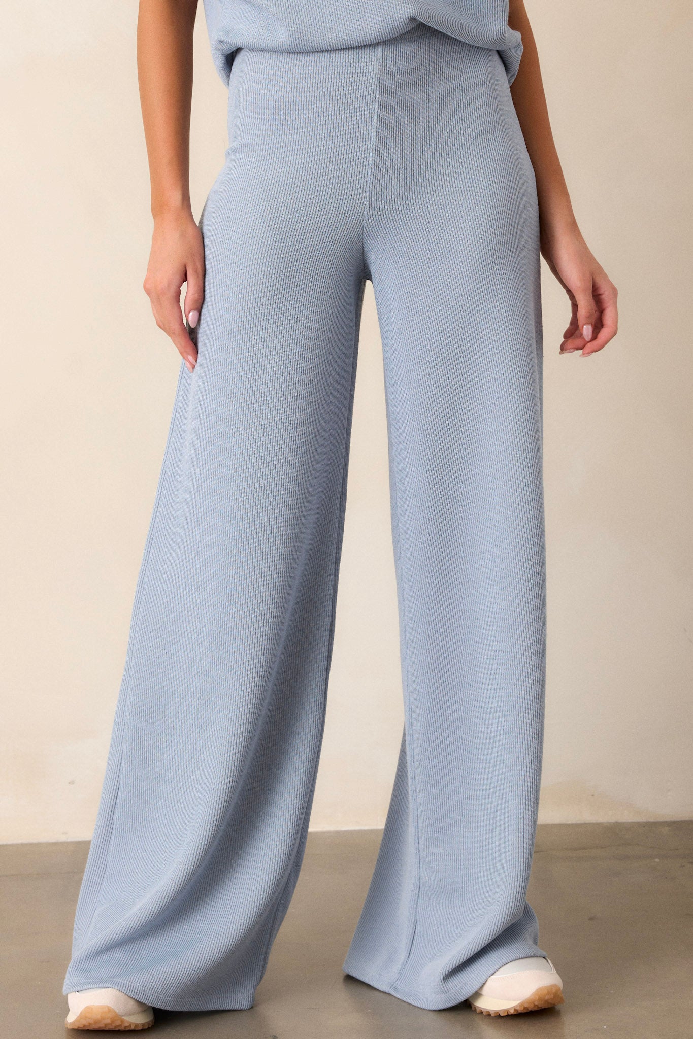 Front view of these blue knitted pants that feature an elastic waist band, a high waisted design, a knit towel like texture on the outside, a soft inside and a wide leg.