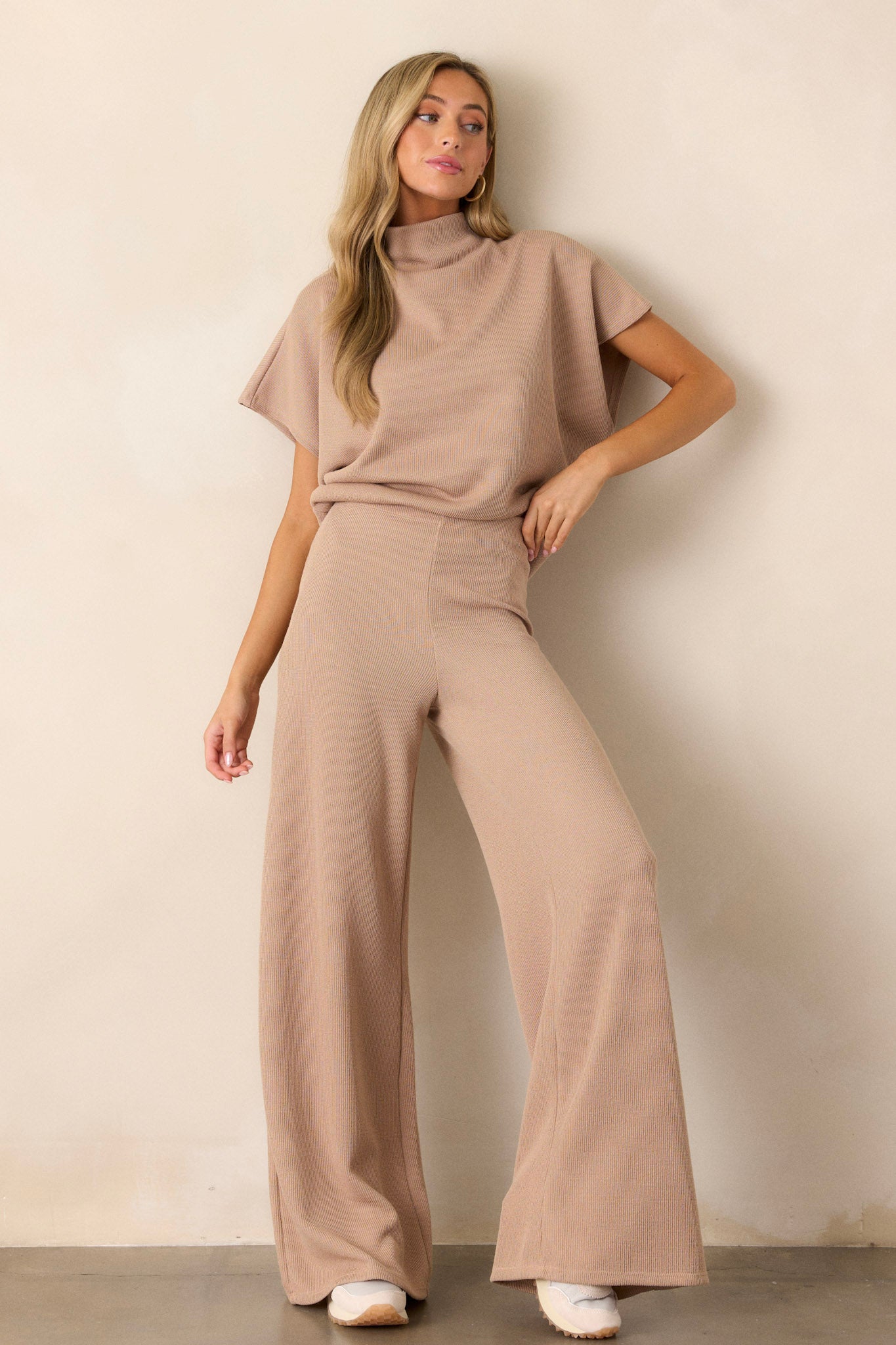 These beige knitted pants feature an elastic waist band, a high waisted design, a knit towel like texture on the outside, a soft inside and a wide leg.