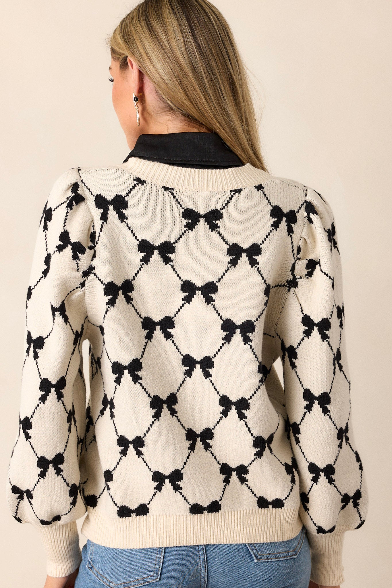 A back view of the sweater, highlighting its clean lines and the ribbed detailing along the collar and cuffs, emphasizing the quality craftsmanship.