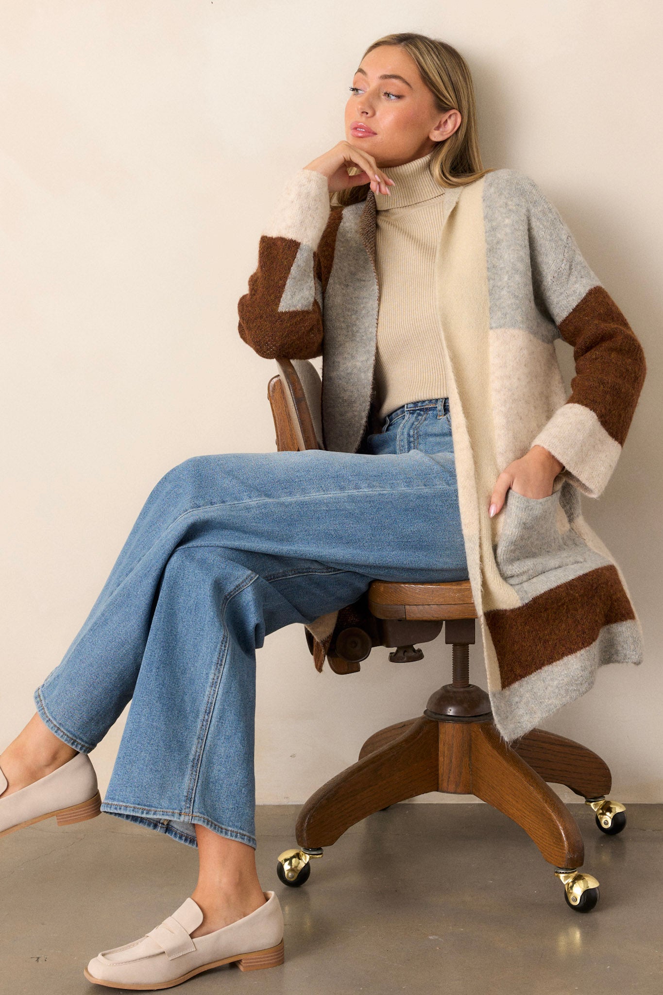 Full body view of this cardigan that features a color block design in shades of brown, grey, and cream.