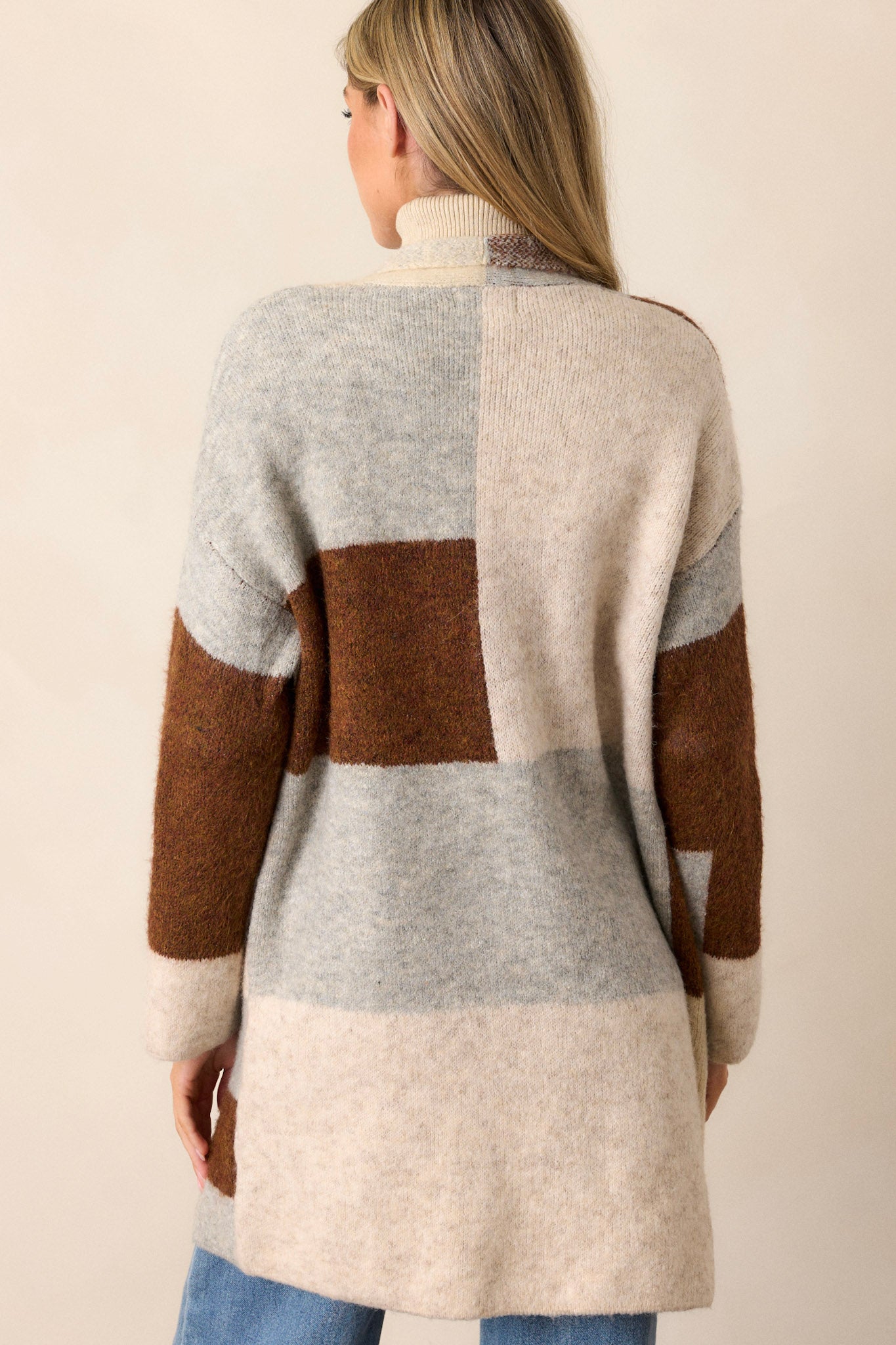 Back view of this cardigan that features color blocking, two functional pockets, and an oversize fit.