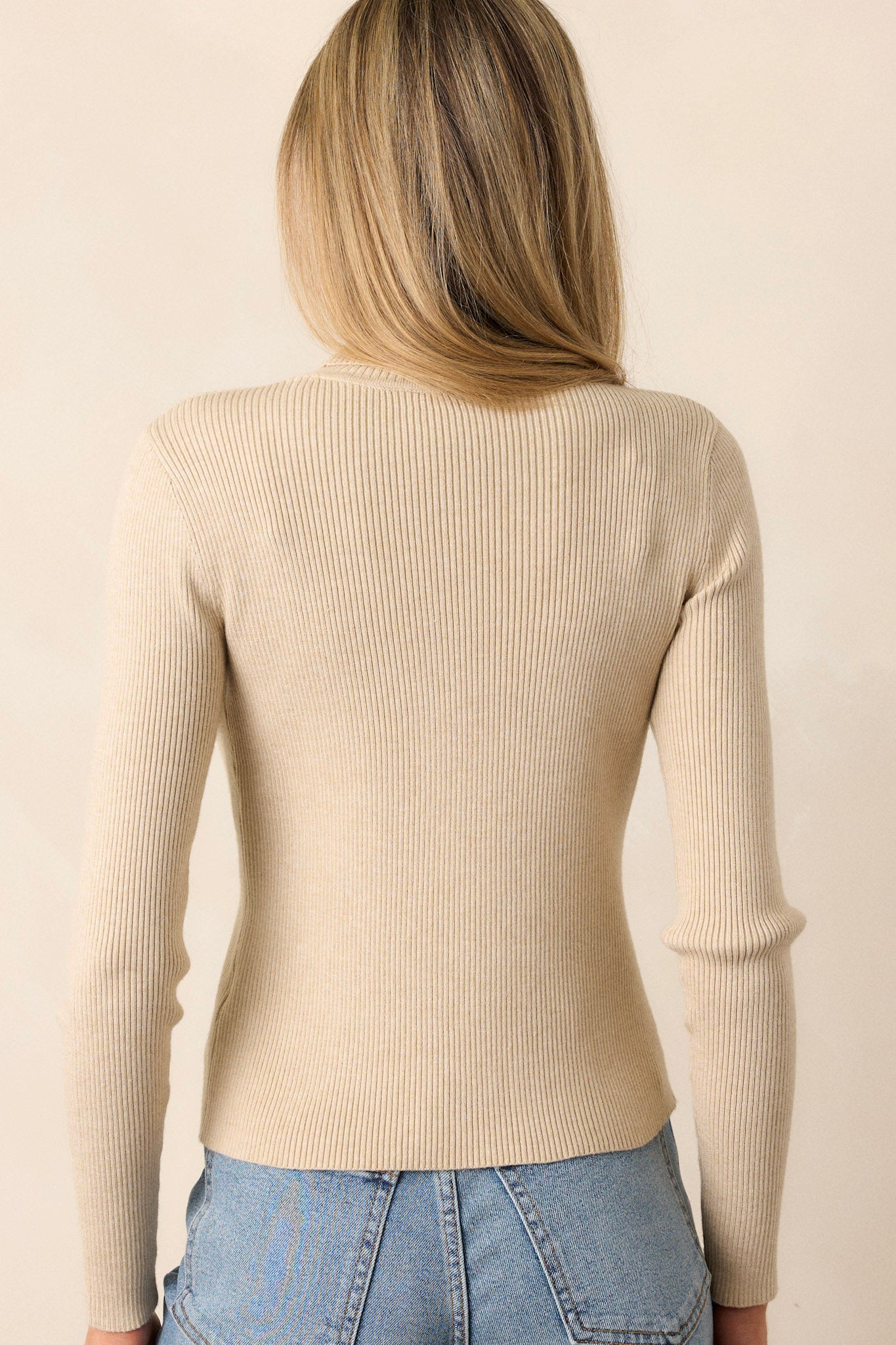 A back view of the khaki sweater, showing the continuous ribbed texture and smooth turtleneck from behind.