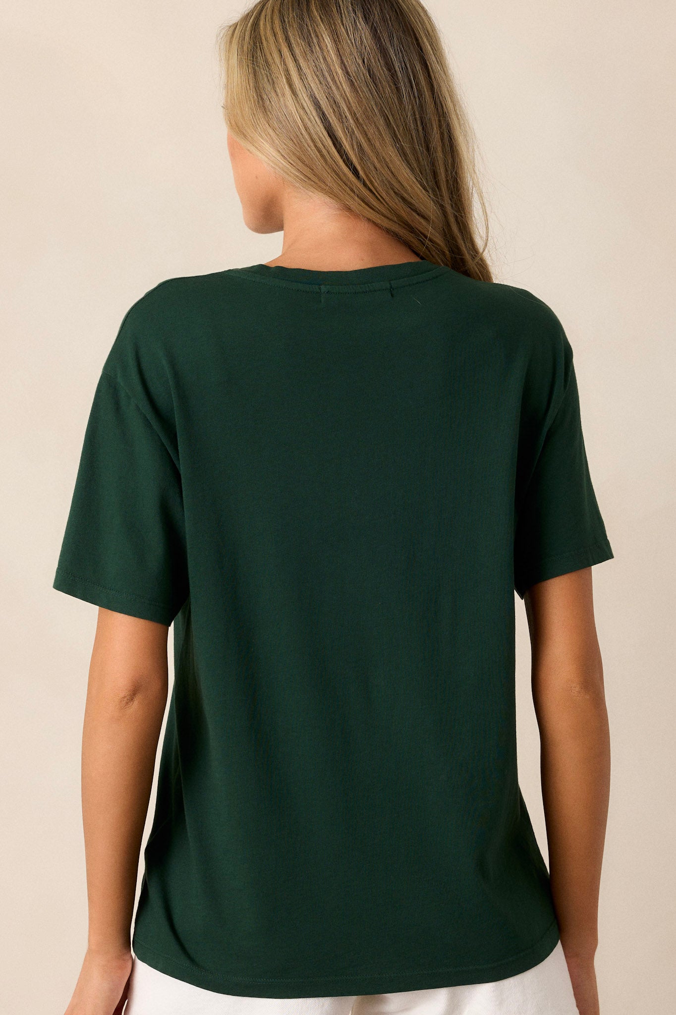 Back view of this hunter green tee that features a rounded neckline, a relaxed fit, a portrait of Elton John kicked back amidst floral accents.