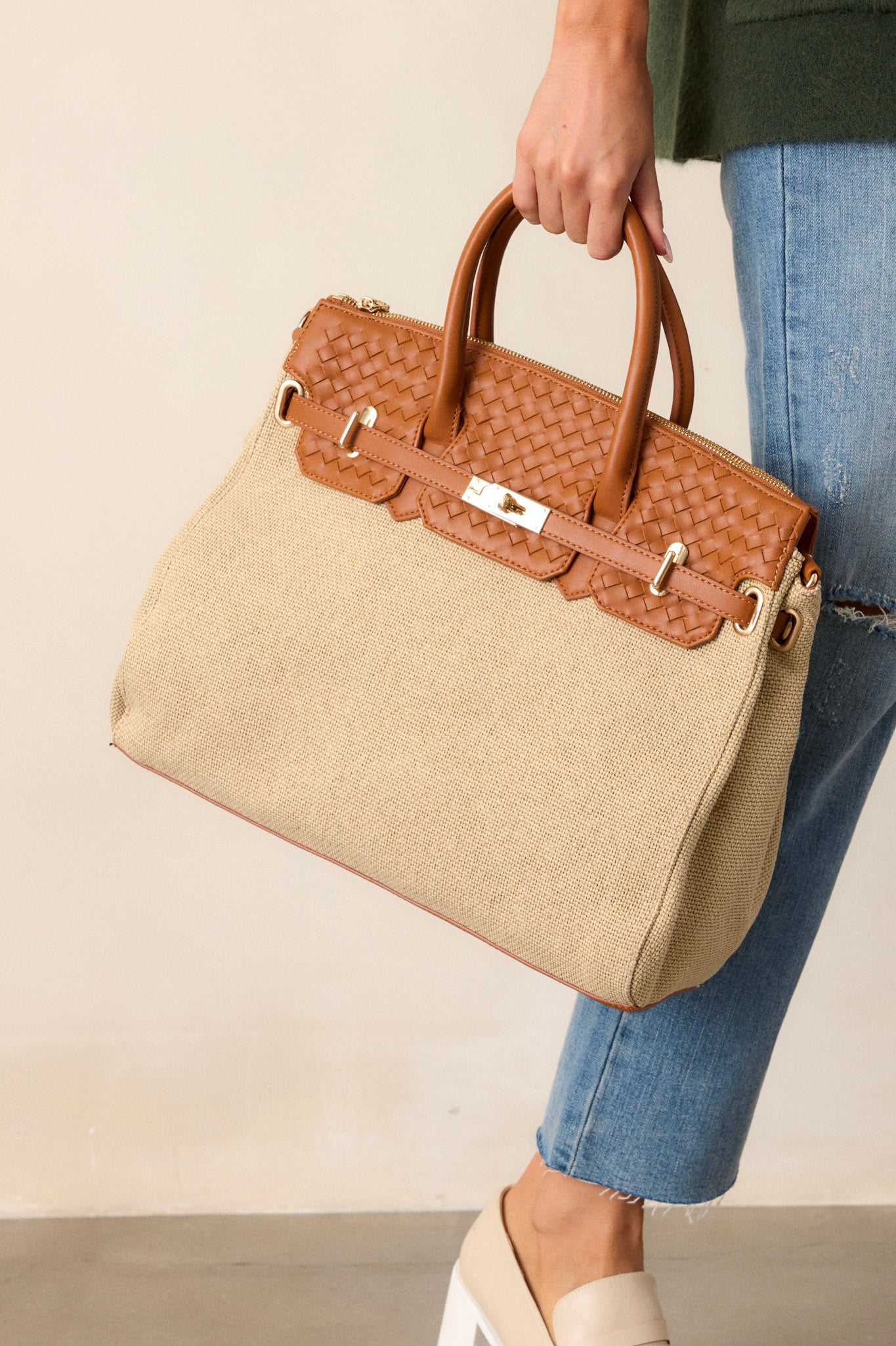 This tan structured tote bag features a beige woven body, a tan woven faux leather contrasting top, gold hardware, gold hoops for optional shoulder bag and tan handles.