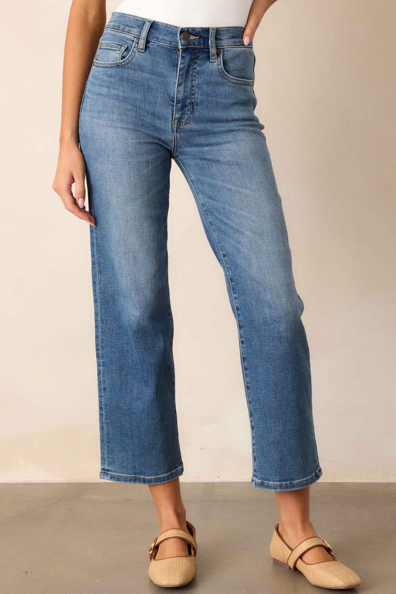 Front view of dark wash straight leg jeans featuring a high waist design, functional front & back pockets, a button & zipper closure, and a straight leg.