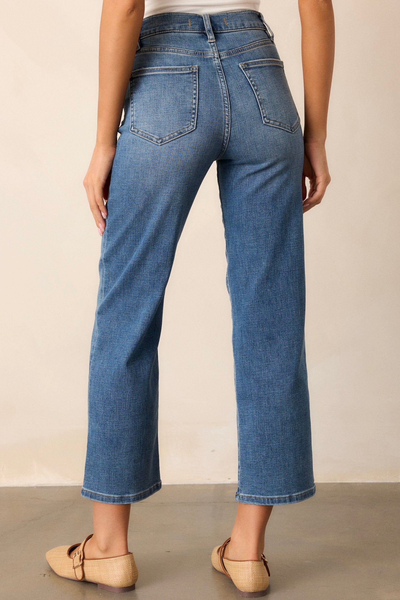 Back view of dark wash straight leg jeans highlighting the overall fit, functional back pockets, and straight leg design.