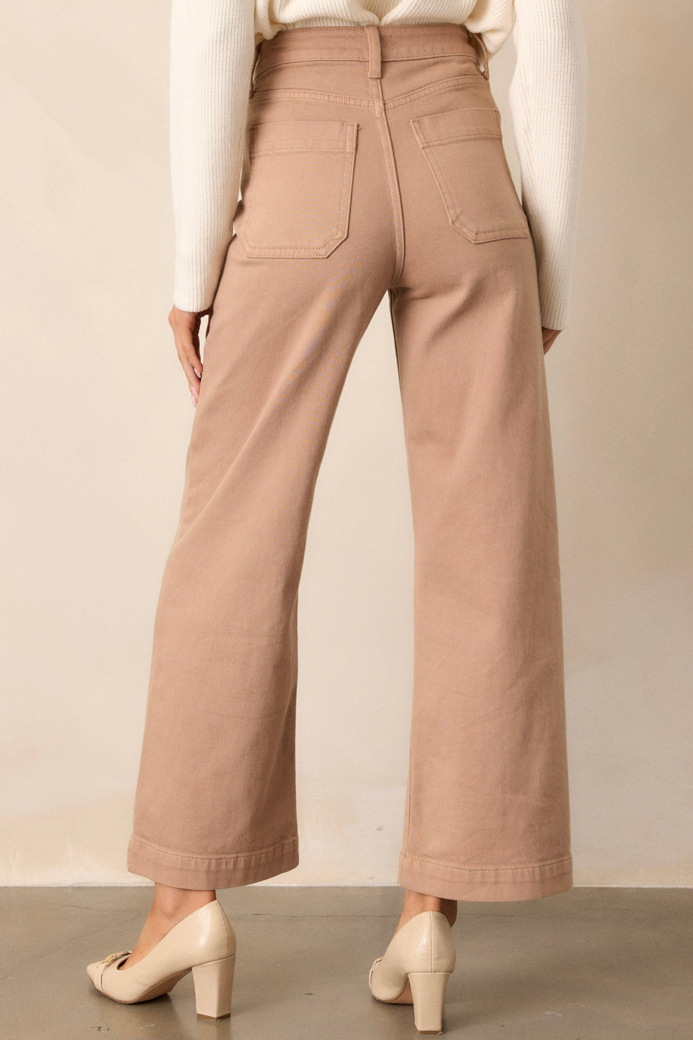 Back view of tan jeans highlighting the overall fit, high waisted design, and functional back pockets.