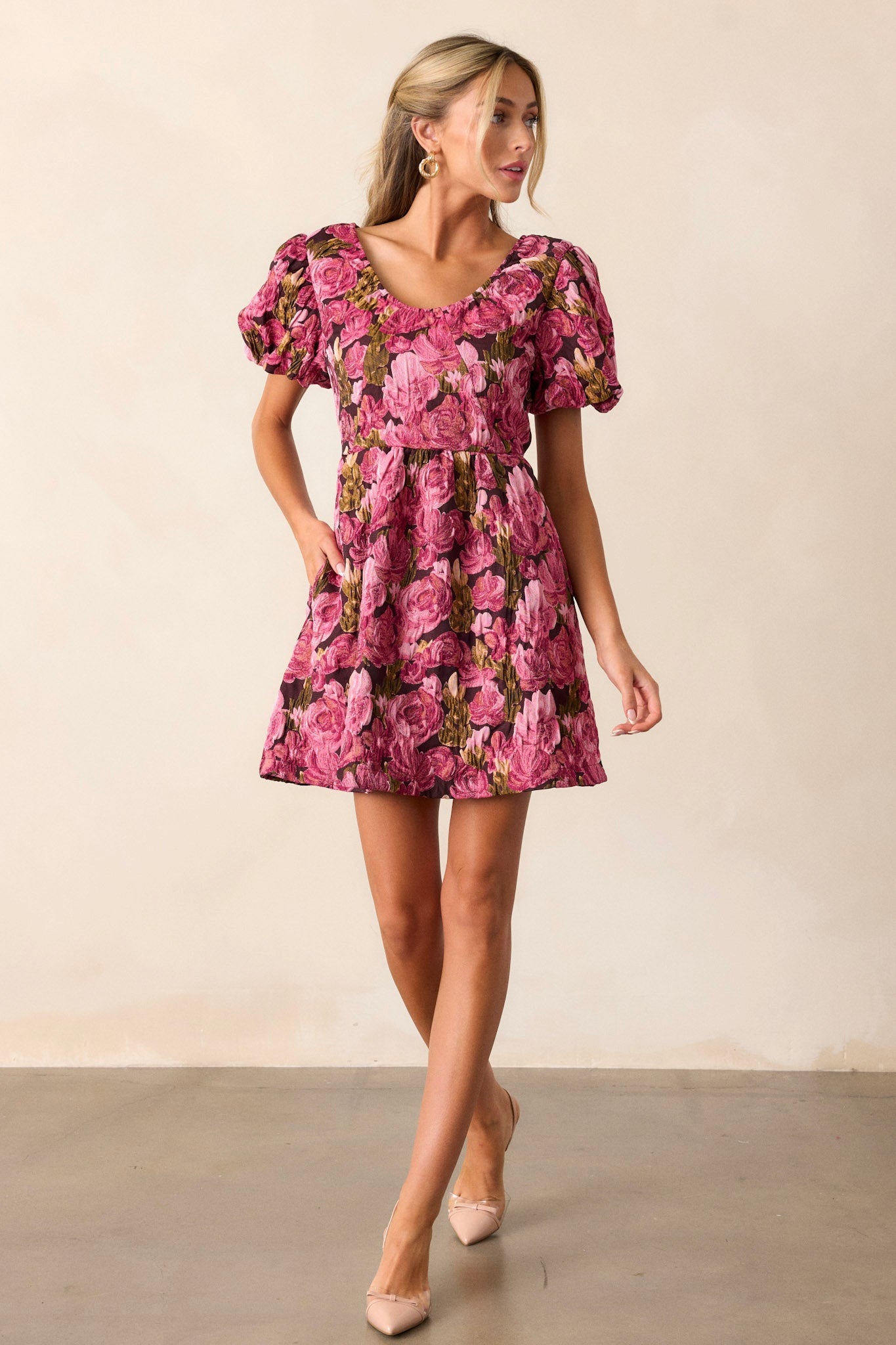 This berry dress features a v-neckline, elastic puff sleeves, a floral jacquard fabric, and a back zipper.