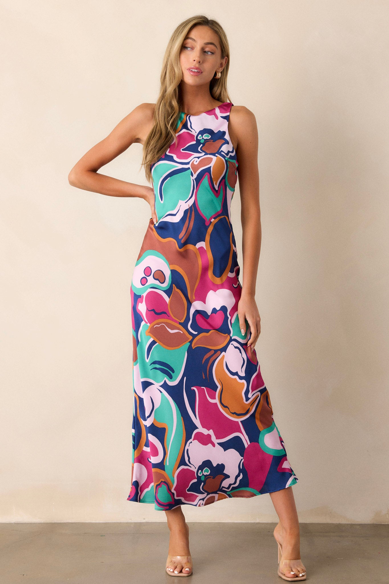 Full body view of this midi dress that features a round neckline, a keyhole button closure, a unique abstract floral print, and a fun midi length.