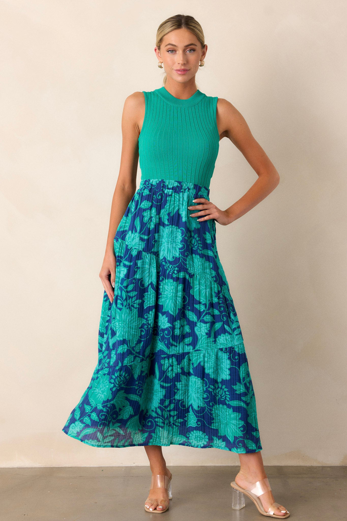 Full-length view of the navy skirt, highlighting the flow and movement of the asymmetrical tiered layers and the green floral pattern across the fabric.