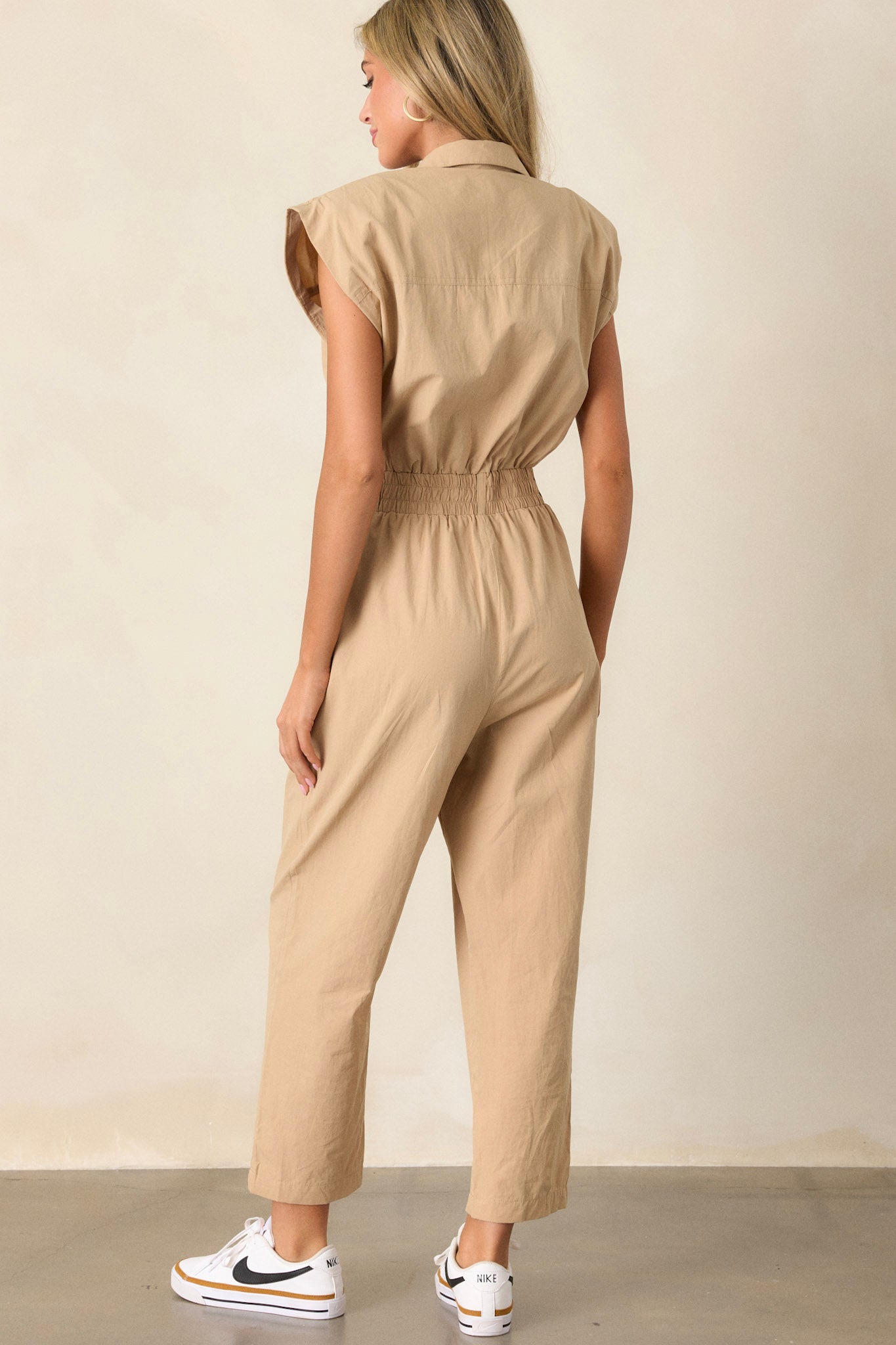 Back view of a jumpsuit highlighting the stretchy soft waistband and the overall fit, with a subtle view of the side pockets.