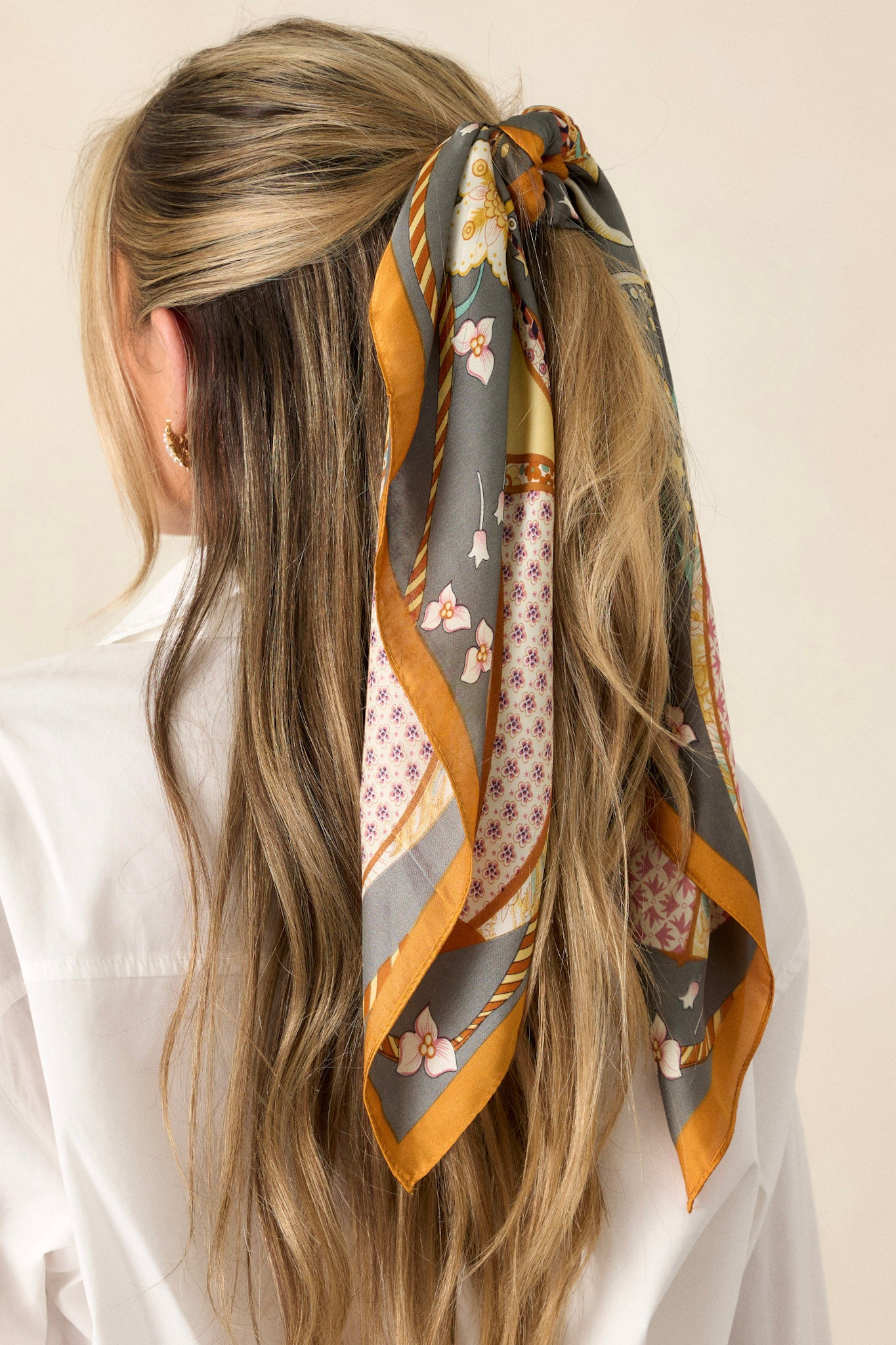 Close-up view of this slate grey multi print scarf that features a satin material, and a multicolored hot air balloon print.