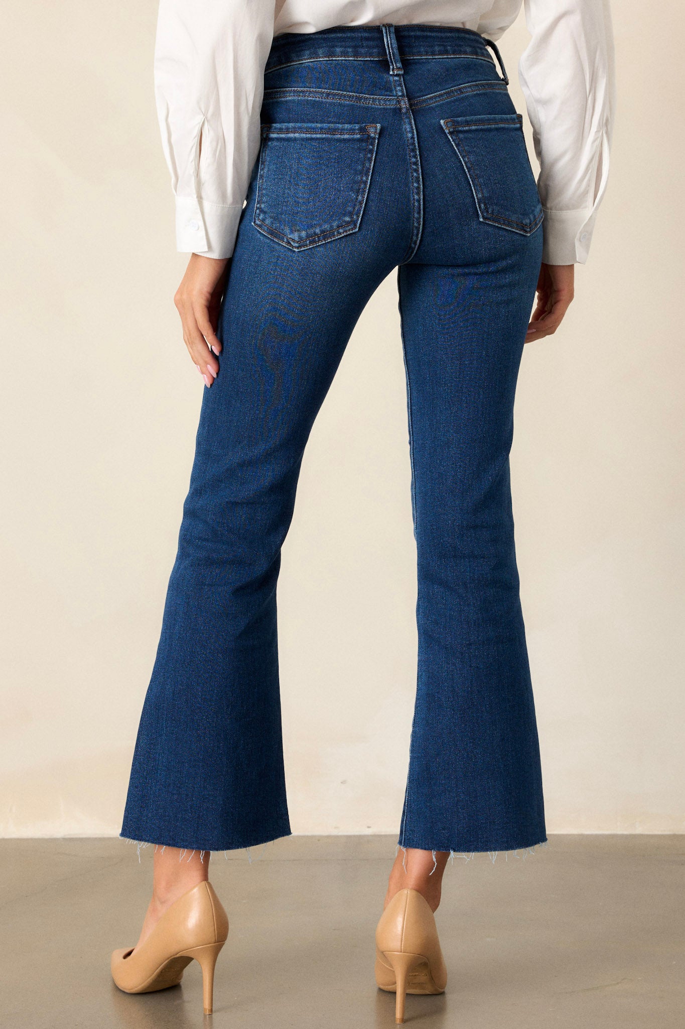 View of the back of the jeans, featuring the functional back pockets and the seamless flow of the flared legs from behind.