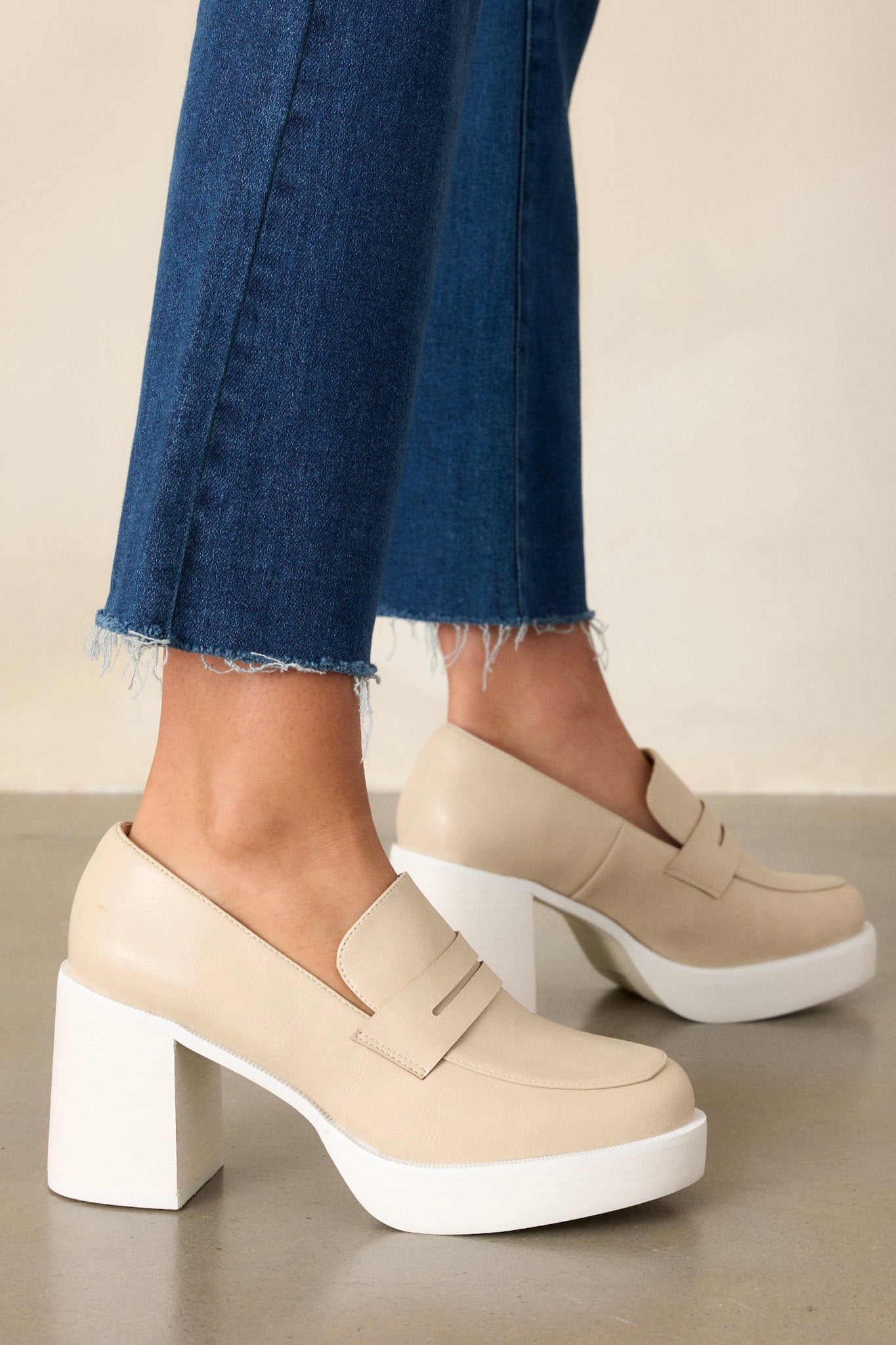 These beige loafers feature a white platform sole, faux leather, and a block heel.