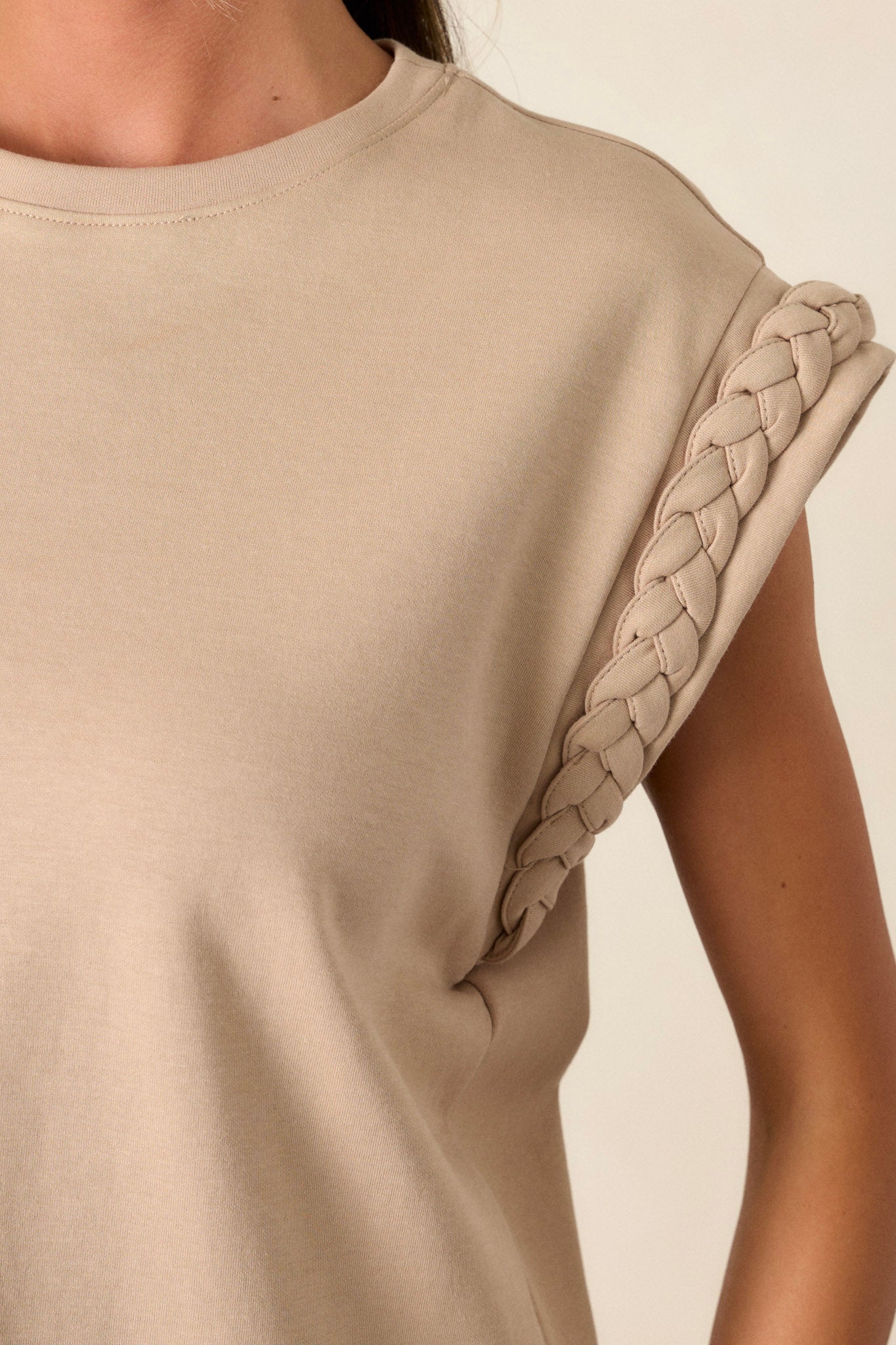 Close-up of the taupe top focusing on the high rounded neckline, cap sleeves, and the intricate braided trim detailing on the sleeves.