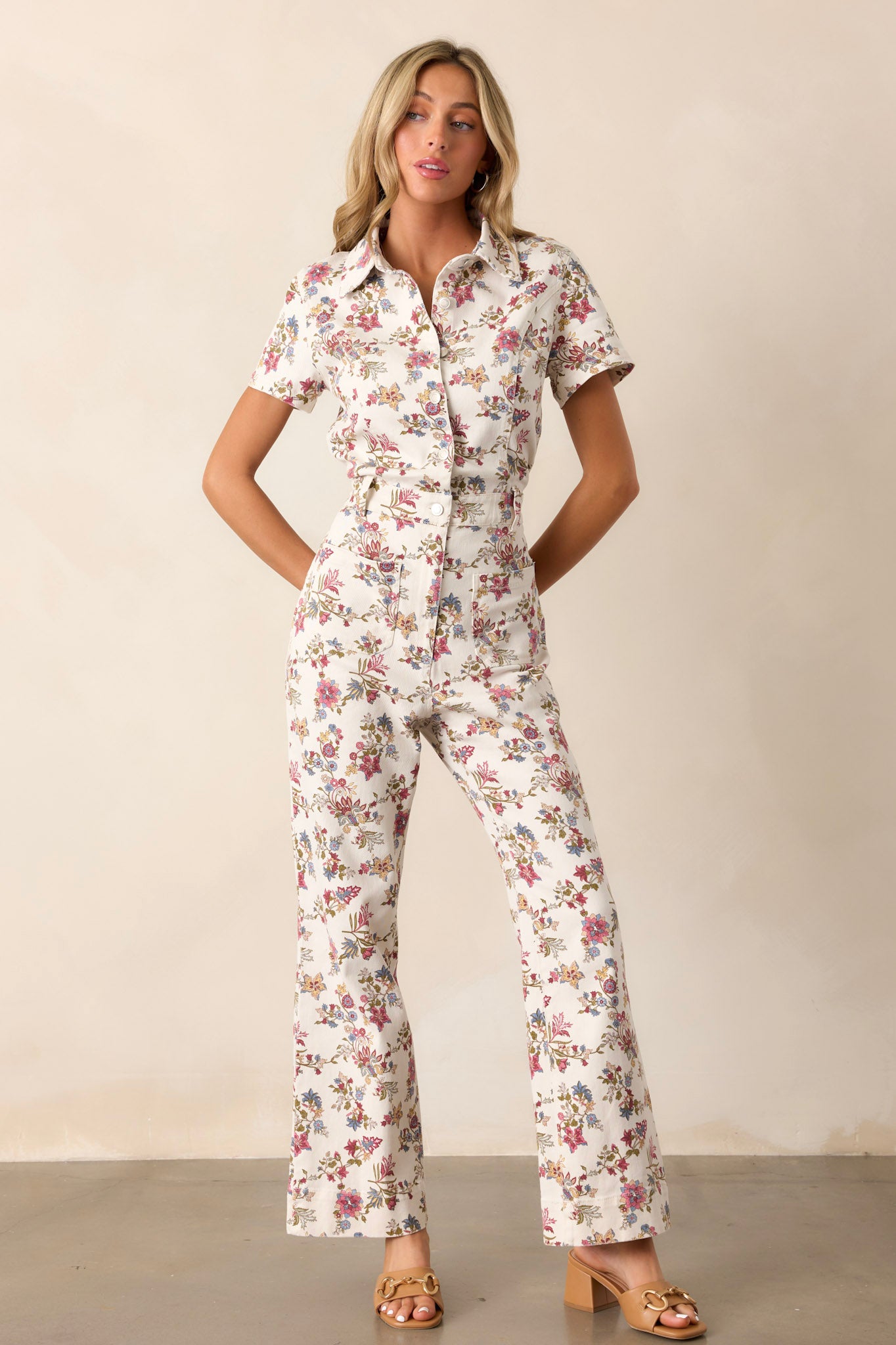 Front view of the jumpsuit featuring four functional pockets, a functional zipper, a collar, and a button-front top for a classic and structured look.