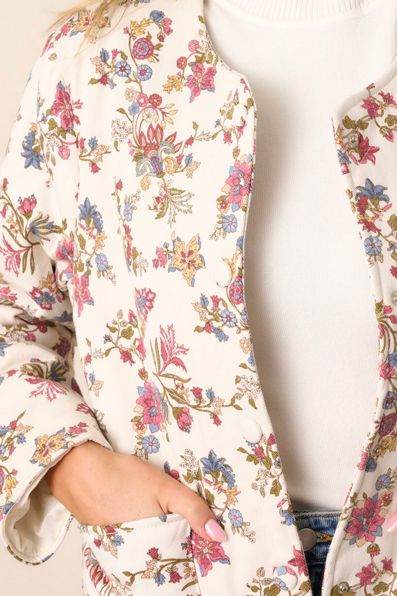 Close-up of the ivory floral jacket focusing on the crew neckline, functional buttons, and the intricate floral pattern on the denim fabric.