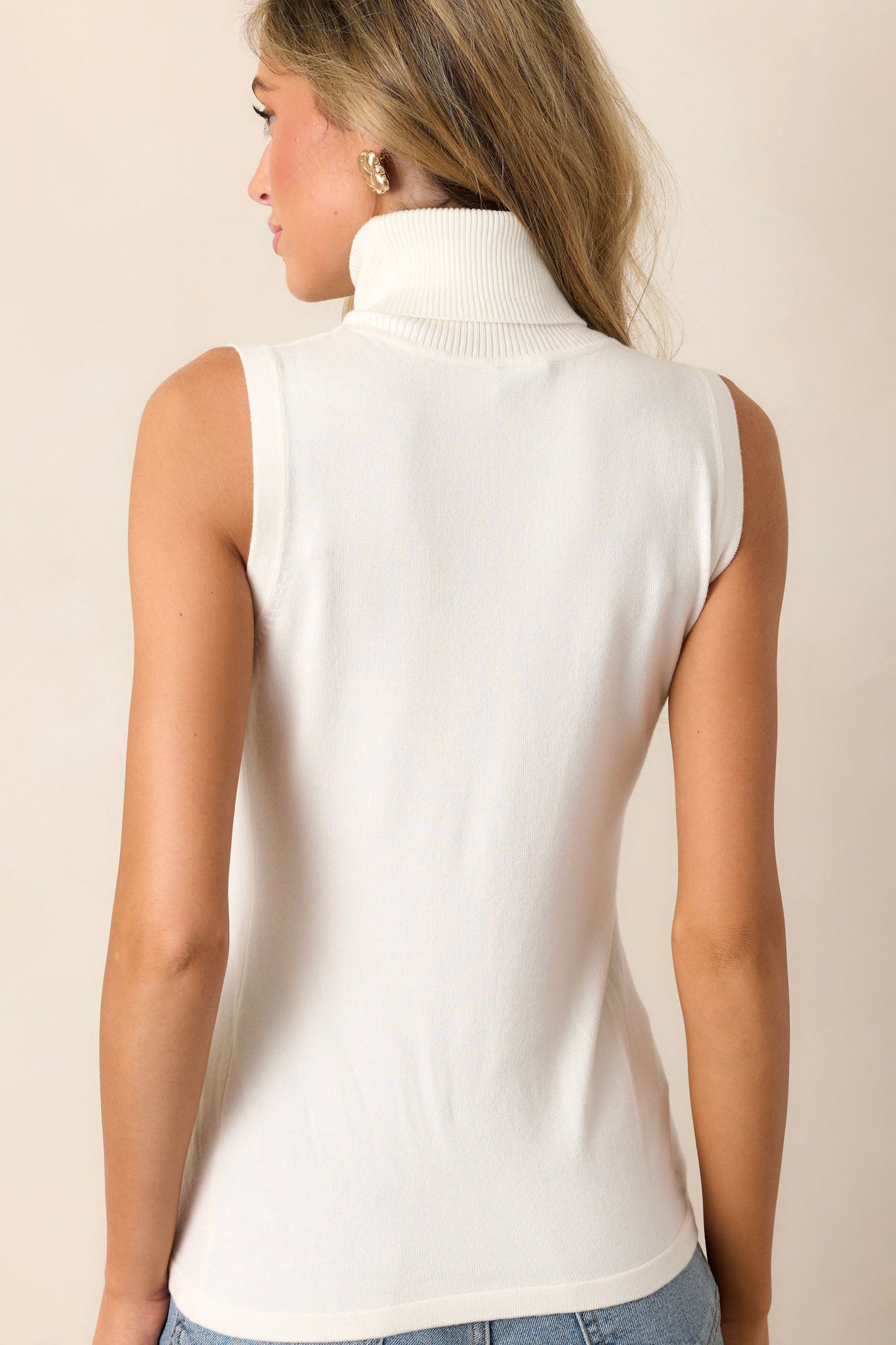 A cropped back view of the ivory ribbed top, highlighting the sleek and seamless sleeveless design.