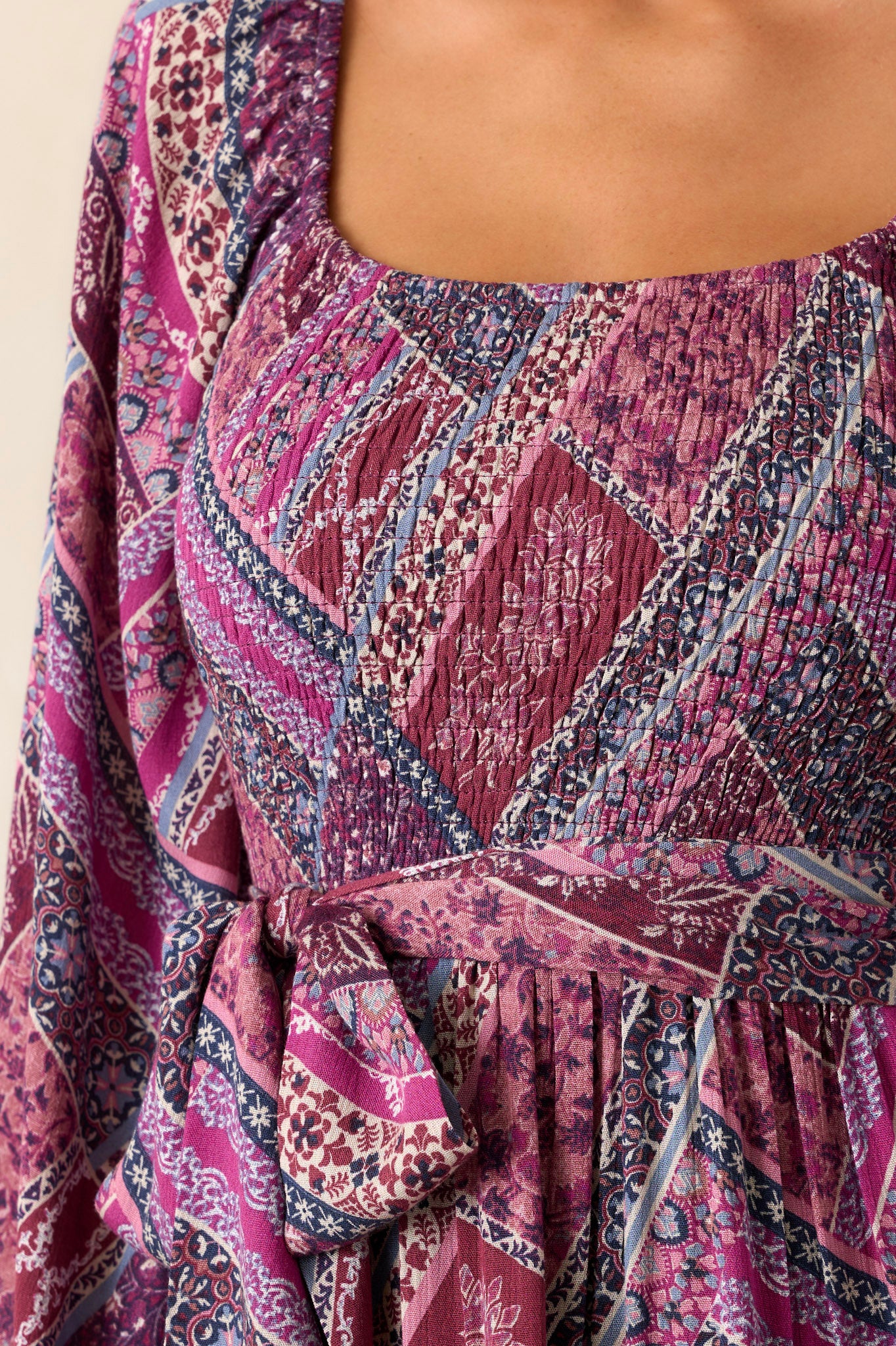 Close-up of the dress focusing on the smocked stretch around the bust and waist, the square neckline, and the self-tie belt feature