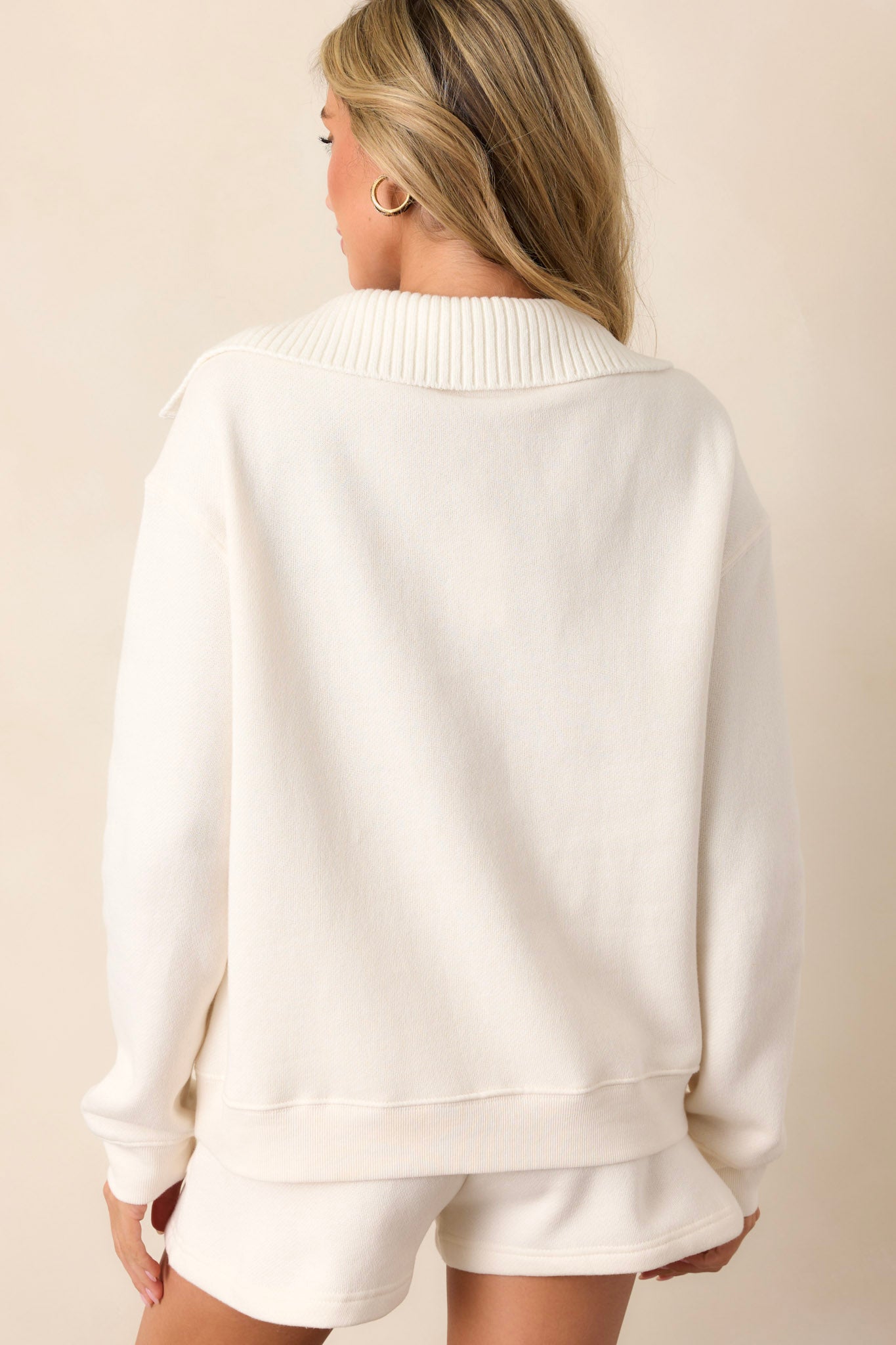 Back view of the sweatshirt highlighting the relaxed fit and the full coverage of the long sleeves.