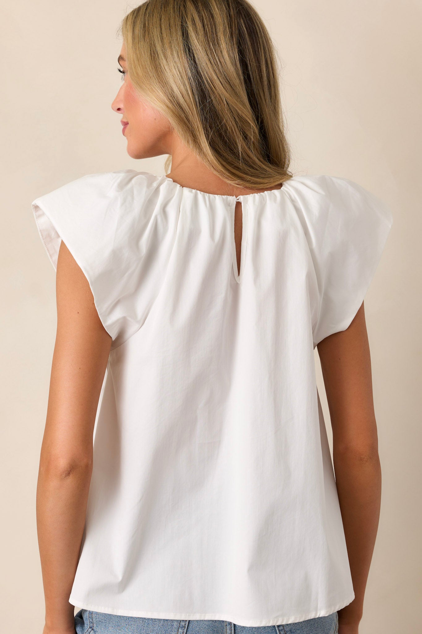 Back view of the white top highlighting the casual fit and the flowing silhouette.