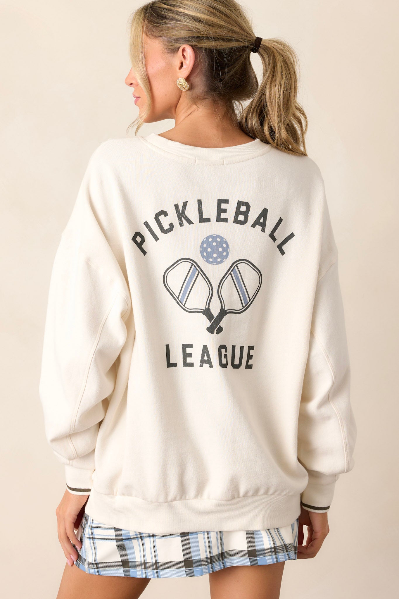 Back view of the sweatshirt highlighting the simple design of the back, with the focus on the stripe detailing on the cuffs and the overall fit.