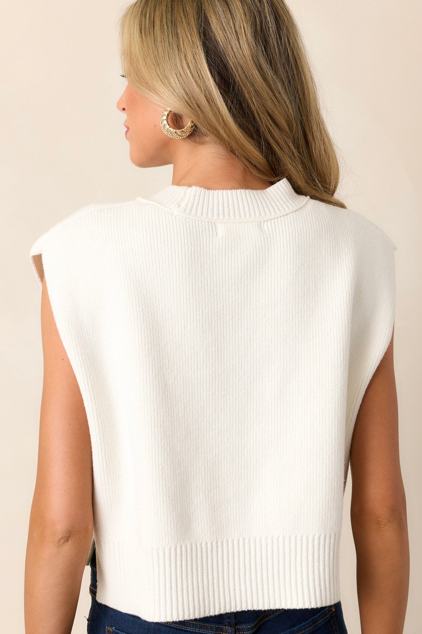 Back view of the top highlighting the knitted fabric, sleeveless design, and the split hemline.