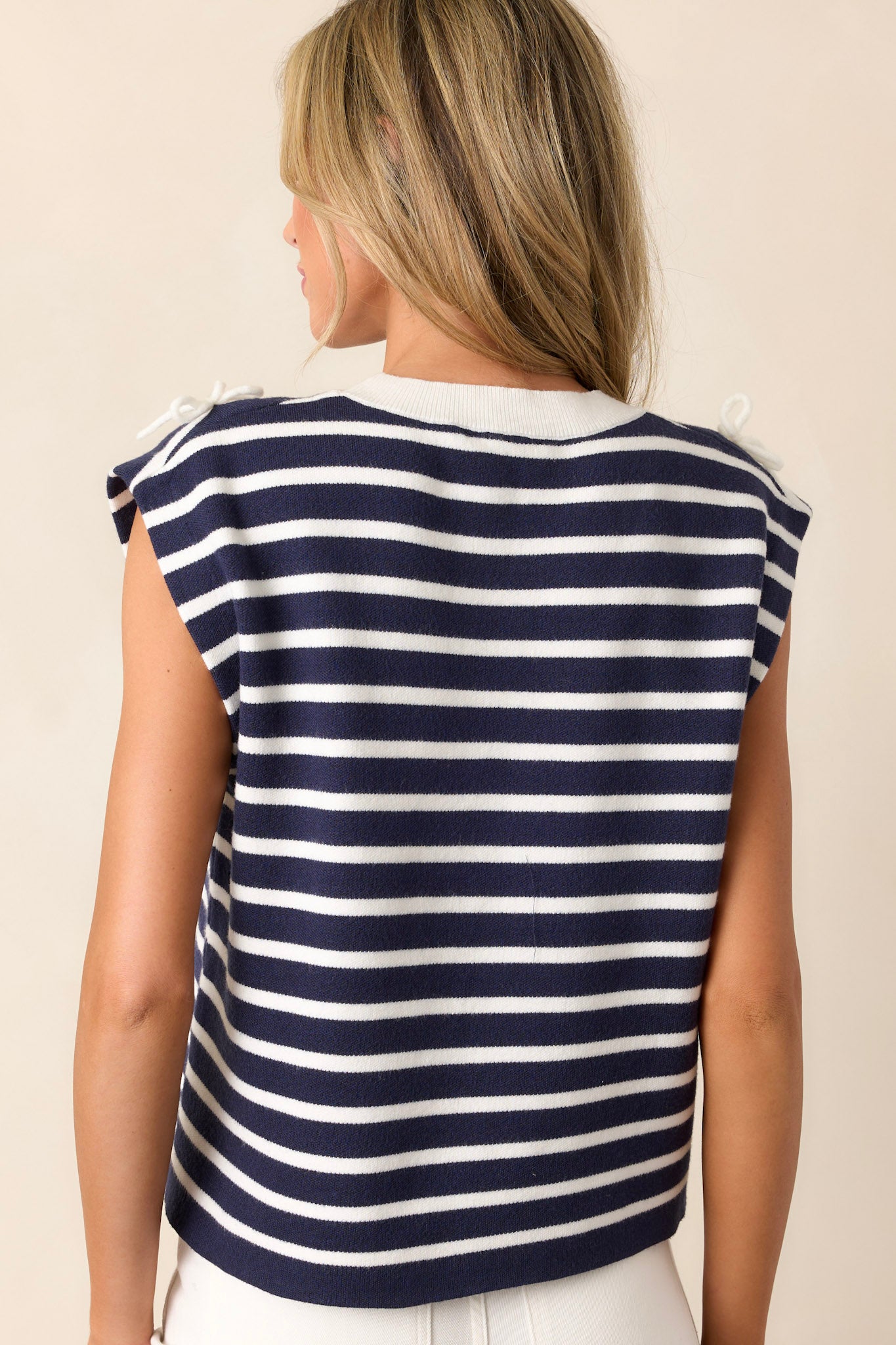 Back view of a navy stripe top highlighting the continuation of the navy and white striped design and the soft knitted texture.