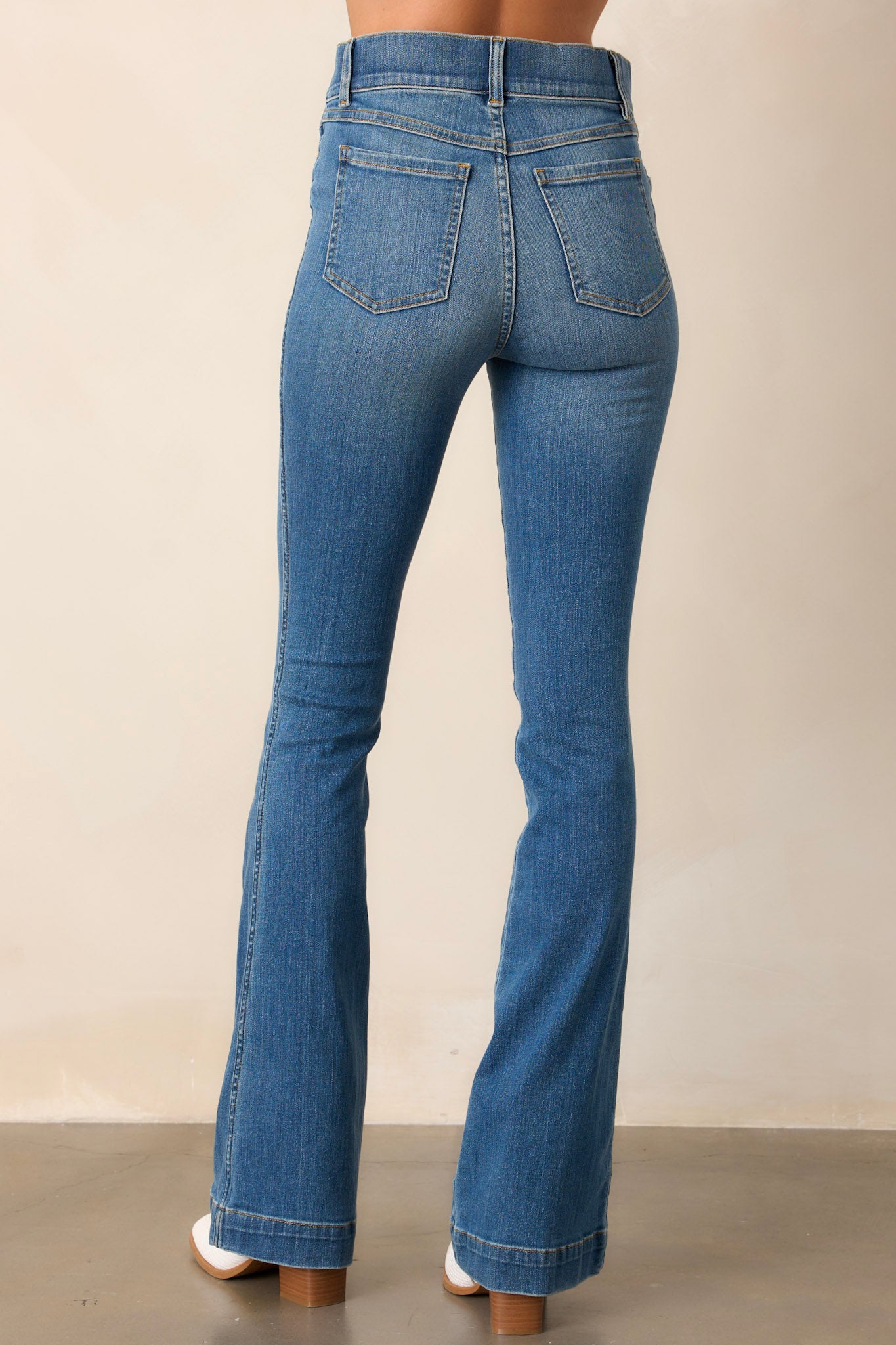 Back view of these jeans that feature a high waist, functional belt loops, slip on design, and a flared leg.