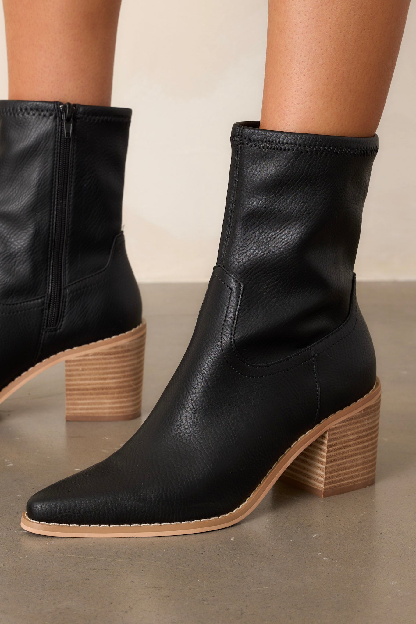 These black boots feature a pointed toe, a platform heel, a discrete side zipper and a tan sole.