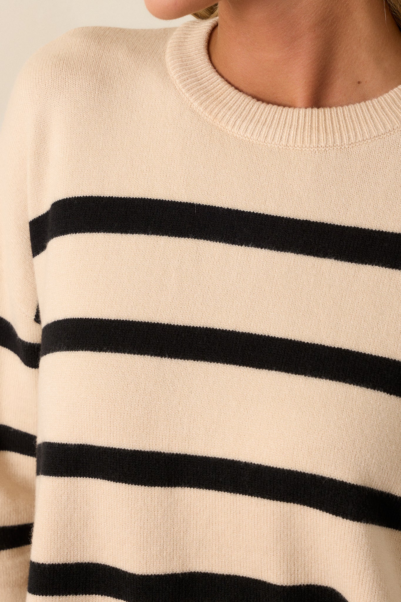 Close-up detail shot of the ribbed hem and side slit, showcasing the knit texture and continuation of the stripe pattern.