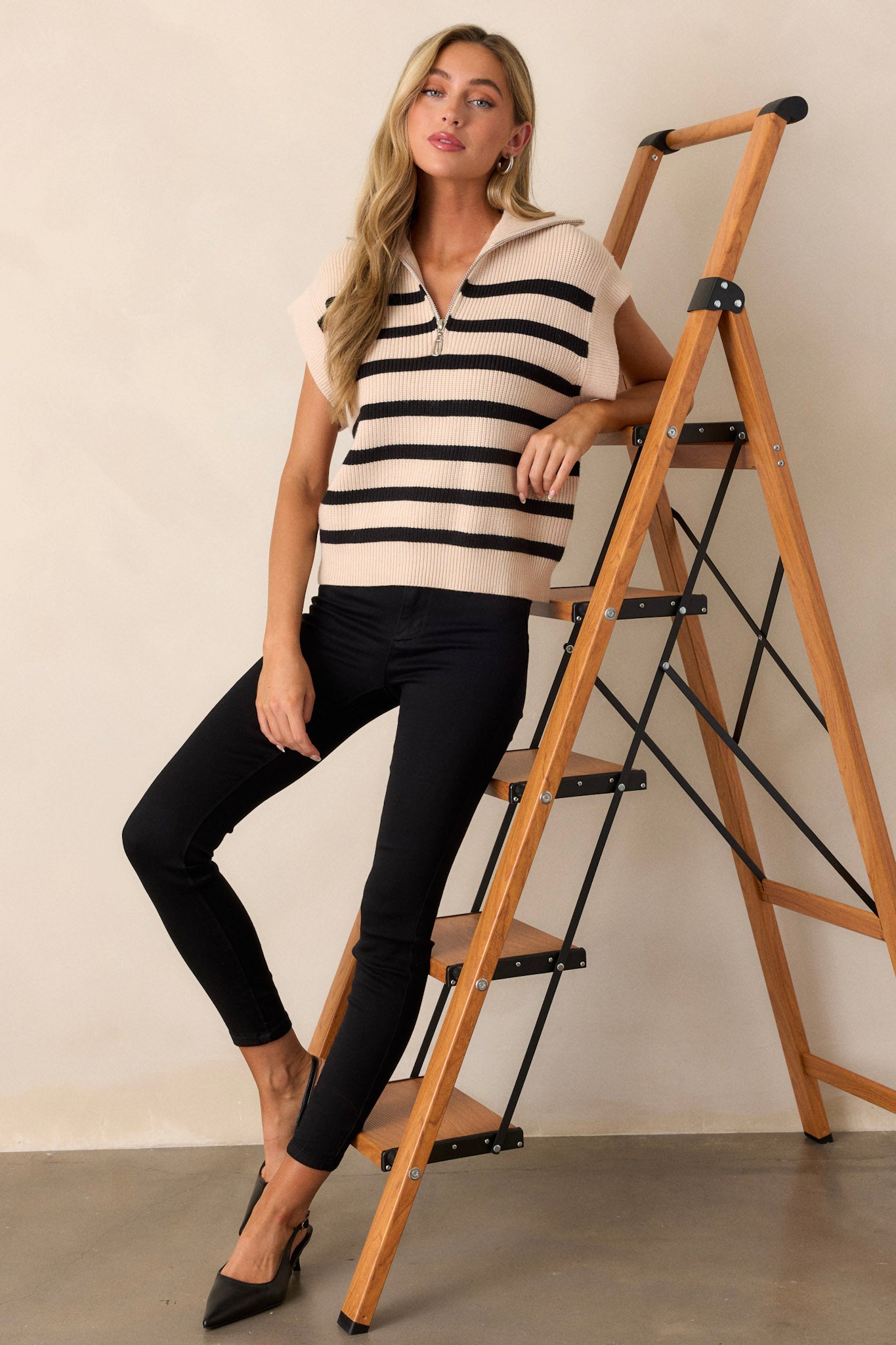 Full length view of of this Ecru top featuring a collared neckline, a functional front zipper, a classic horizontal stripe pattern, cap sleeves, a thick hemline and a relaxed fit.