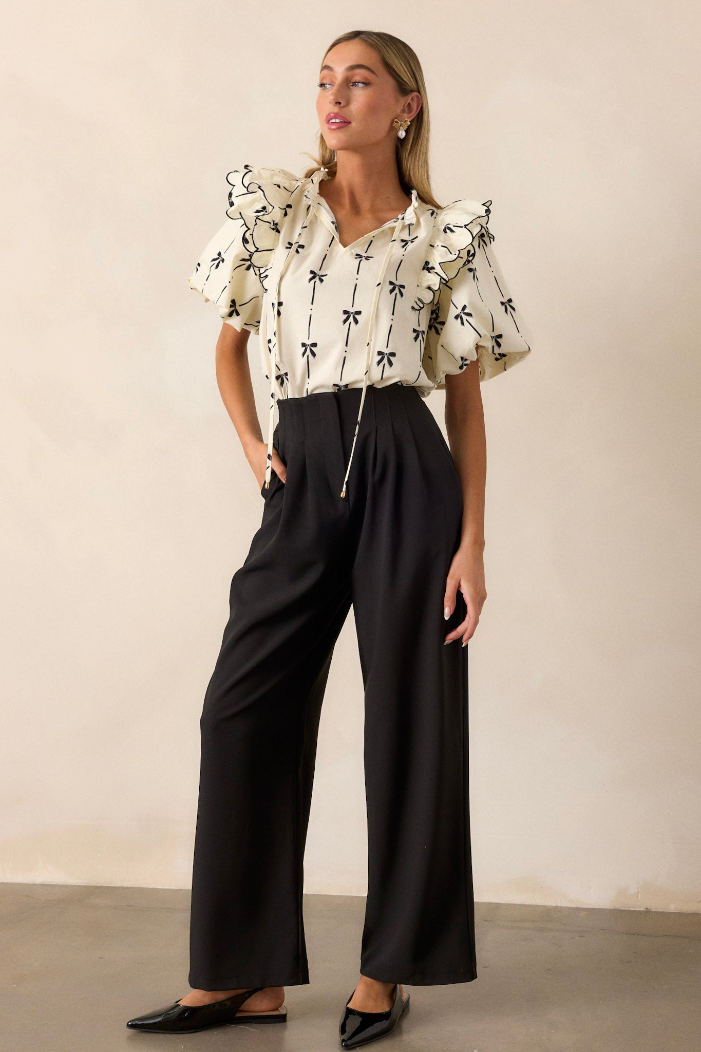 A full-length side view of the top, showing the short puff sleeves with elastic cuffs and the flow of the ruffle details along the sleeve and neckline.