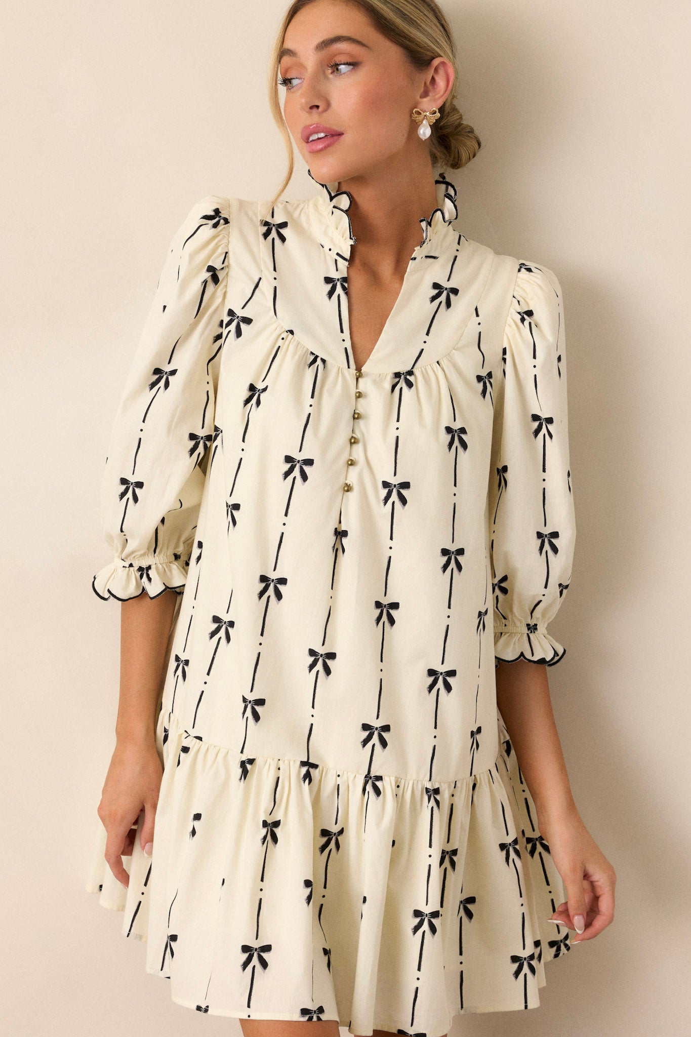 A cropped shot showing the three-quarter length sleeves with elastic cuffs, showcasing the sleeve design and the black bow print on the fabric.