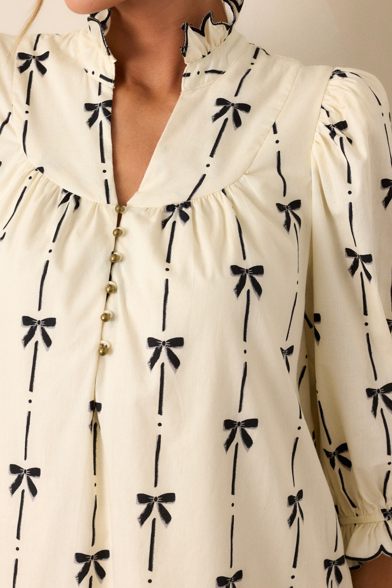 A close-up image of the black bow print on the ivory fabric, showing the pattern and texture in fine detail.