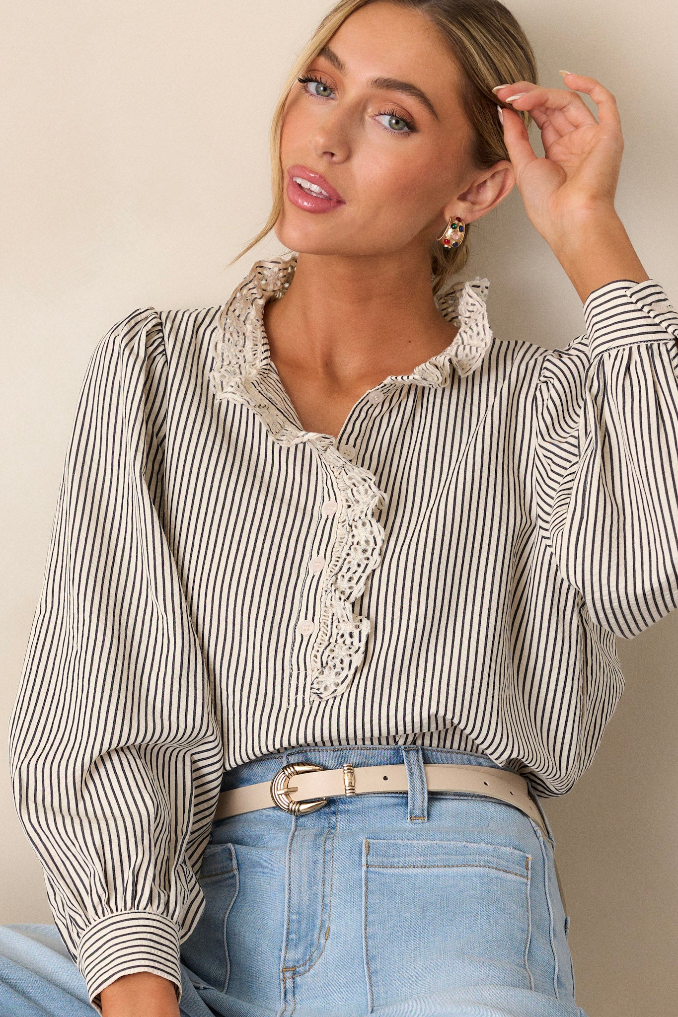 This navy stripe top features a lace collar, a functional button front bust, a vertical stripe pattern, brown and ivory stripes and puffed long sleeves.