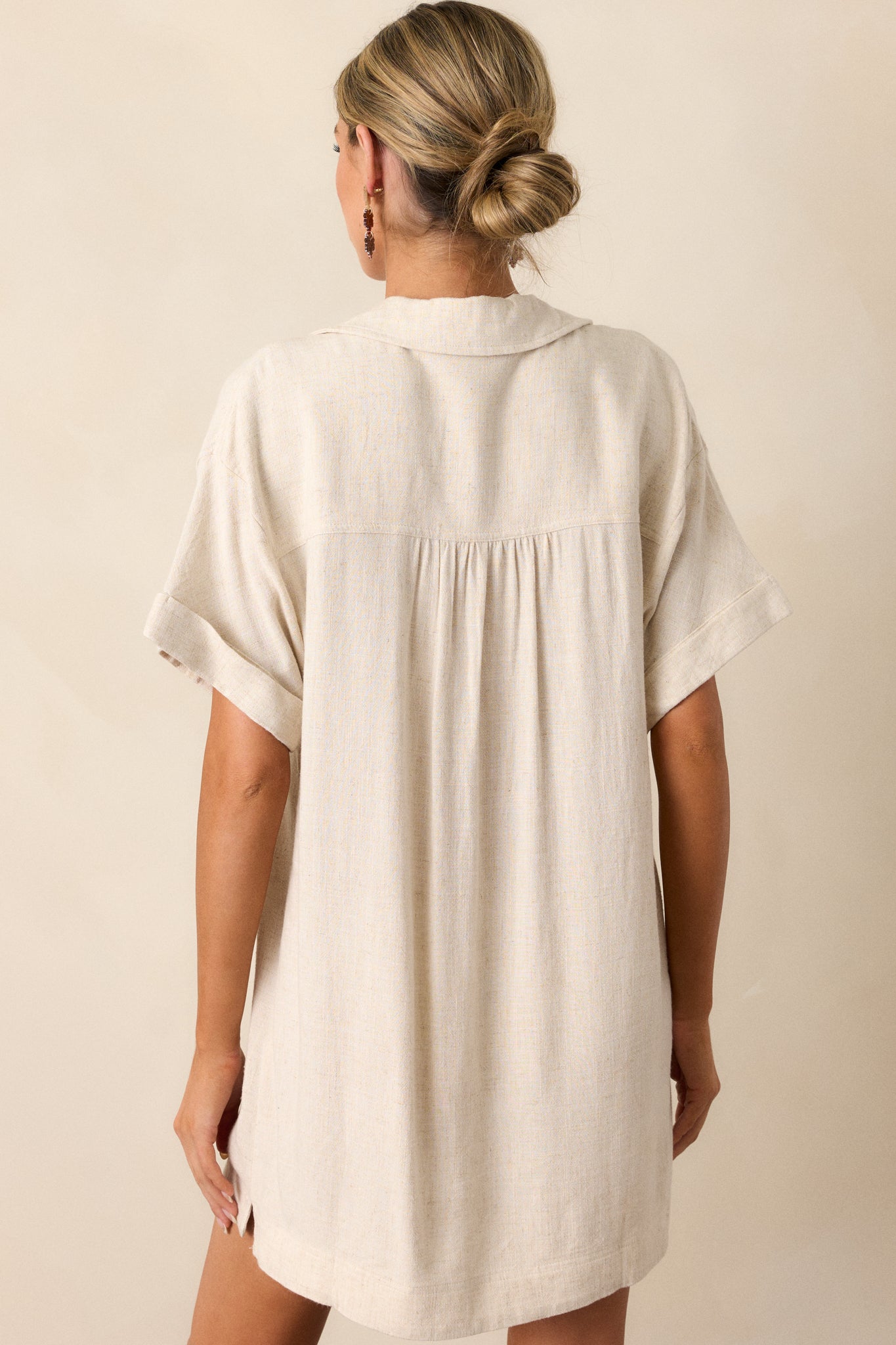 View of the back of the dress, featuring the clean, relaxed fit and the continuous smooth flow of the fabric down to the hem.