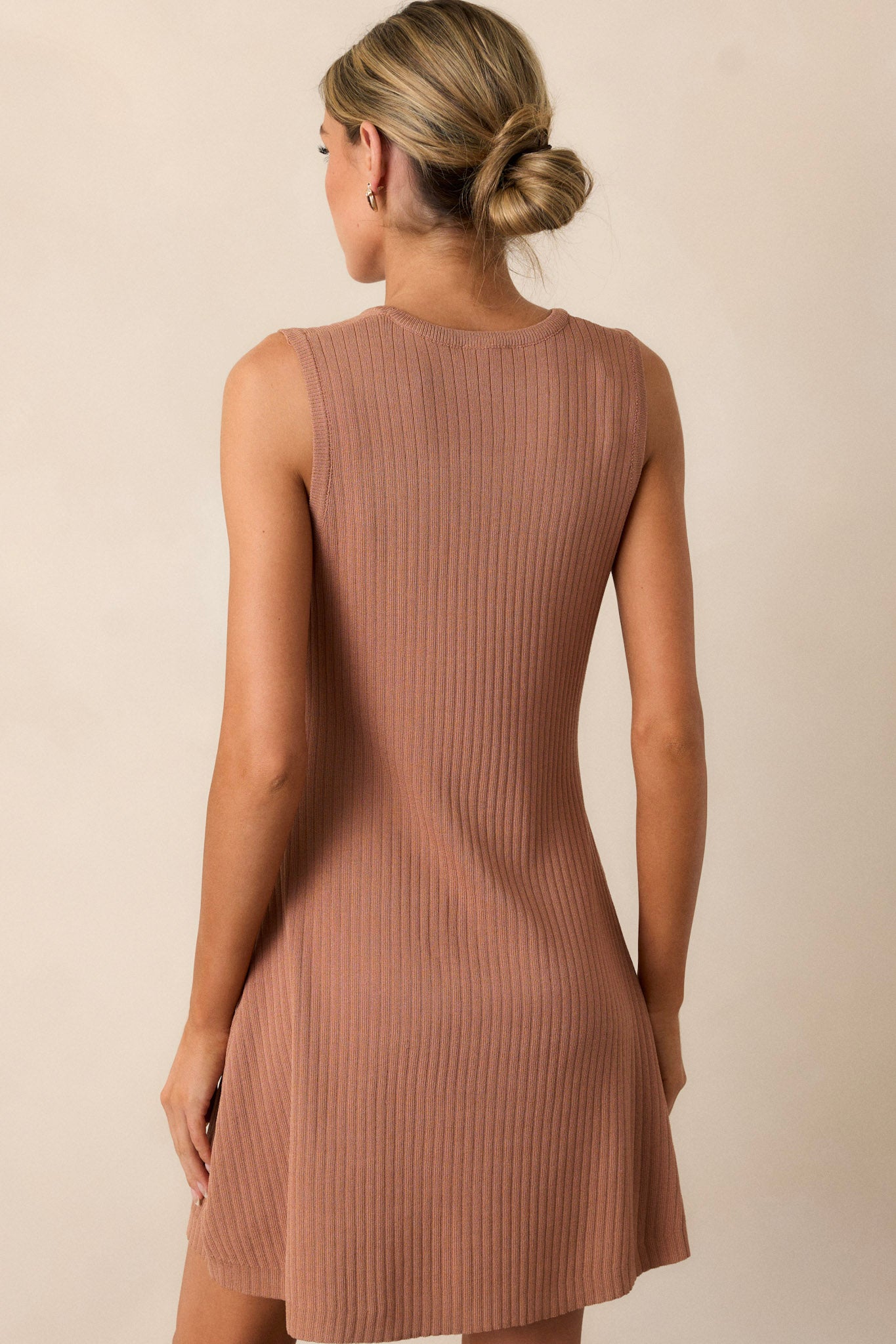 A view of the back of the camel brown top, highlighting the simple lines and the continued ribbed design that enhances the overall aesthetic.