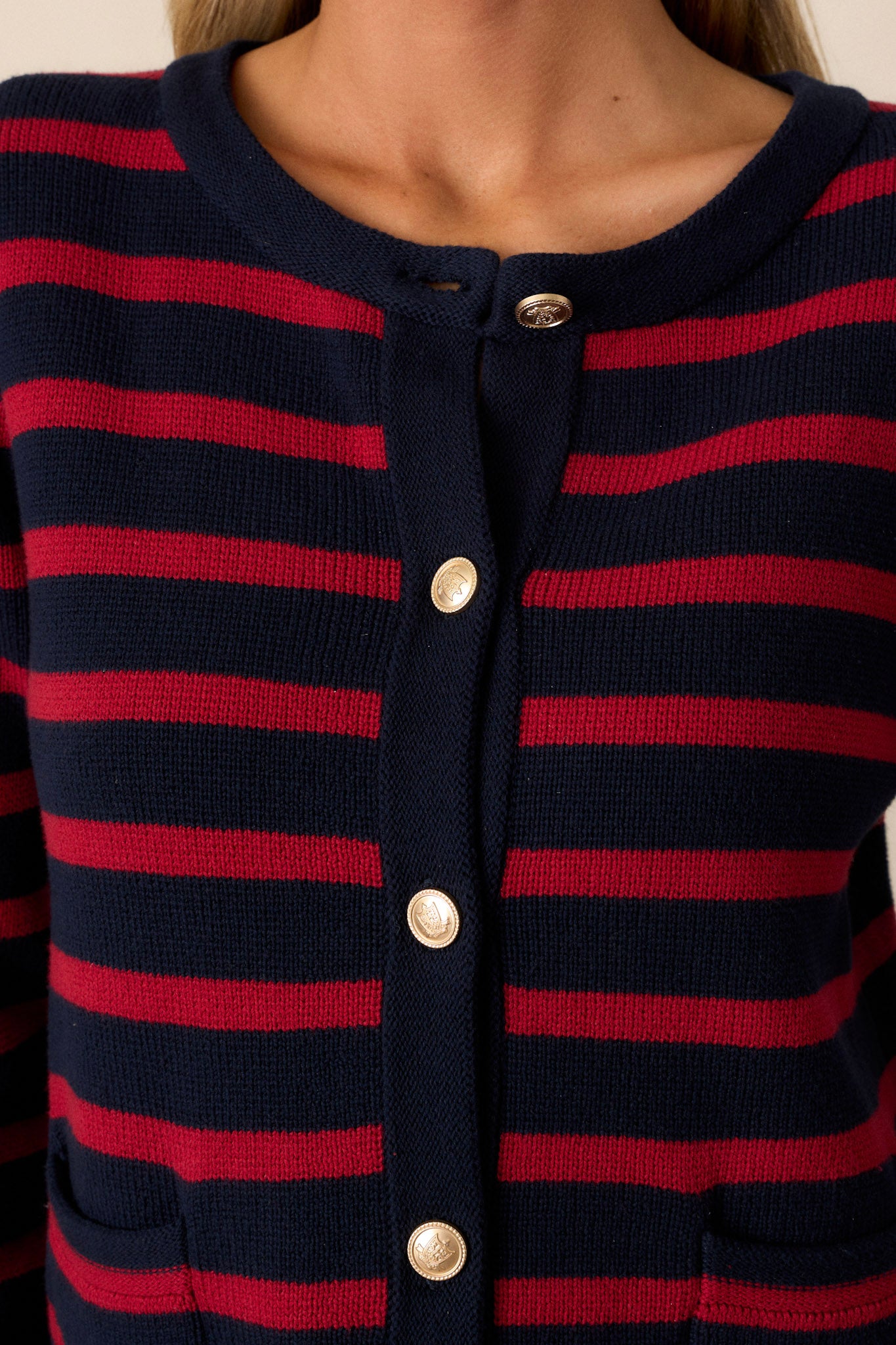 Close-up of this red & navy cardigan showing the detailed gold buttons, crew neckline, and the texture of the fabric.