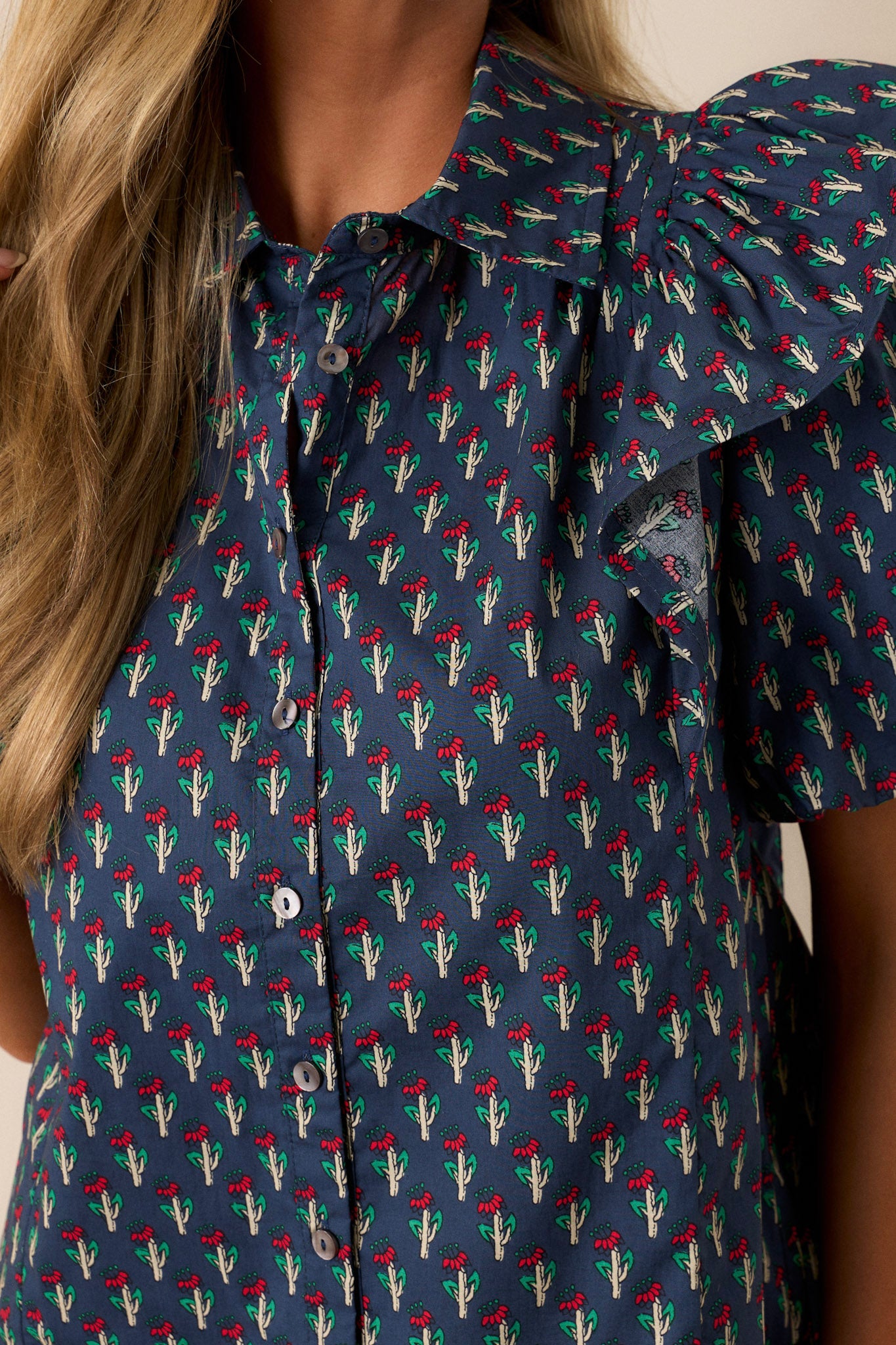 Close-up of the red and green floral print on the navy fabric, showing the intricate pattern and color contrast.