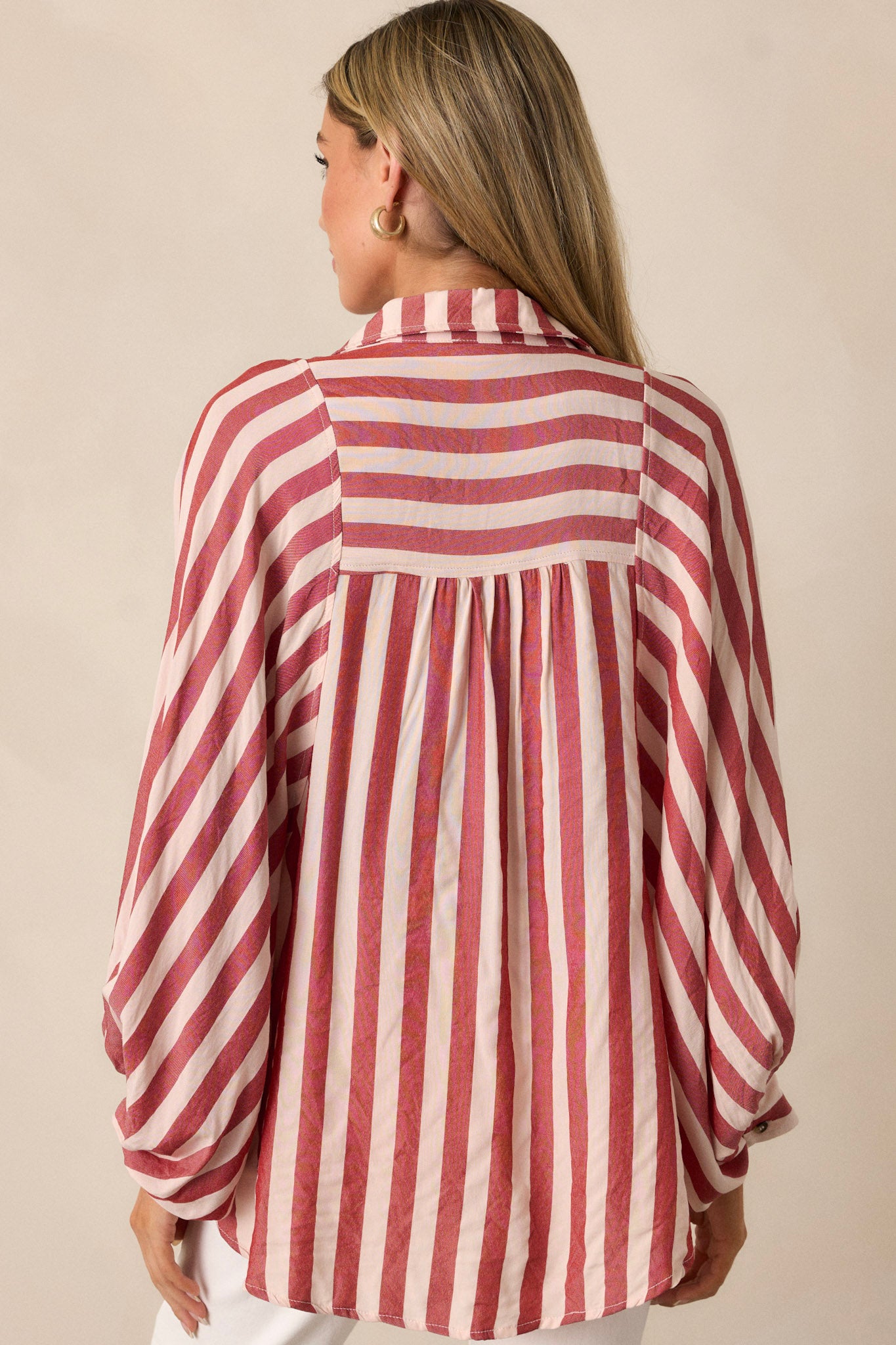 A view of the back of the red top, showcasing the simplicity of the design while maintaining the vertical stripe pattern.